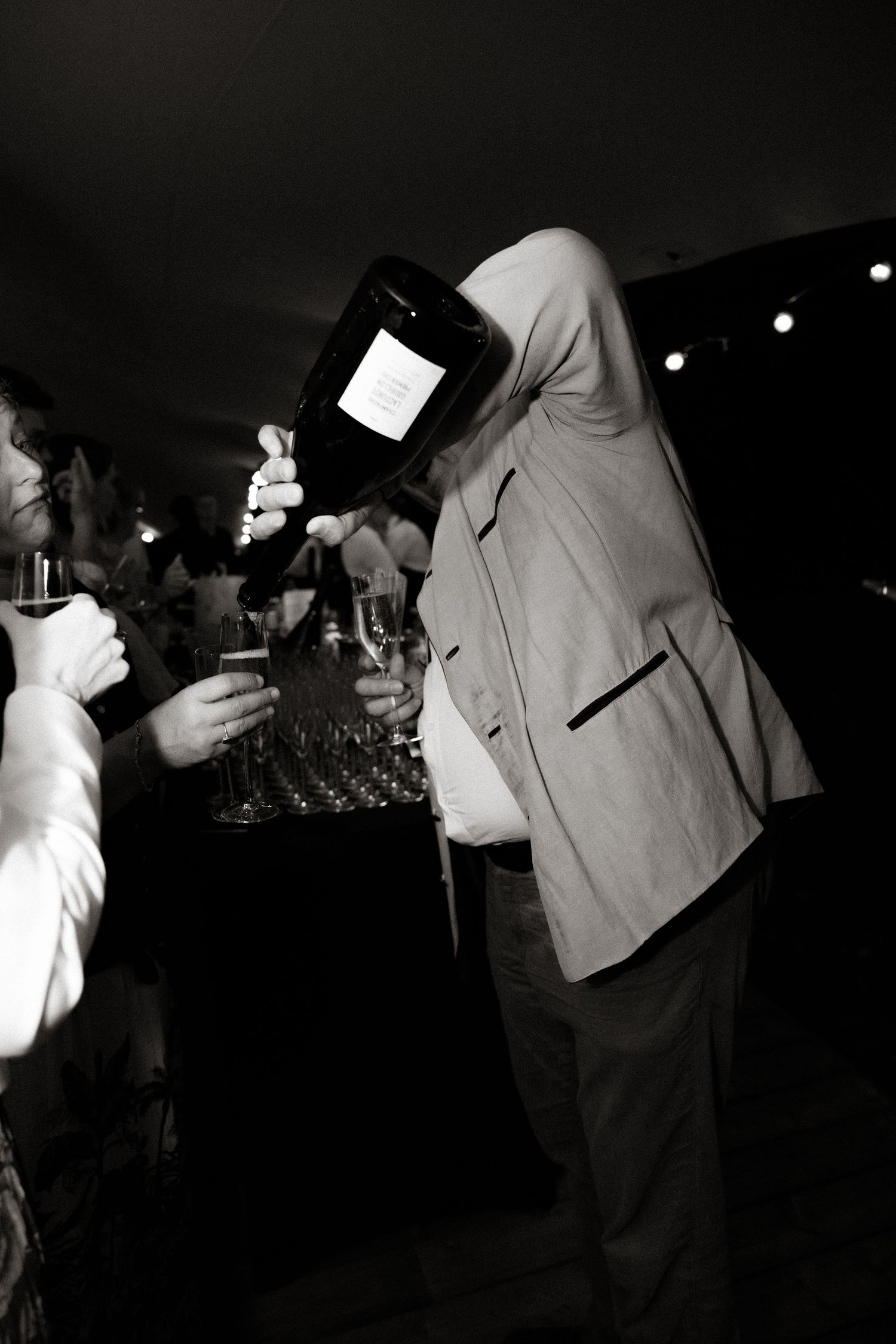 Black and white photos of people dancing and celebrating at a dimly lit party.