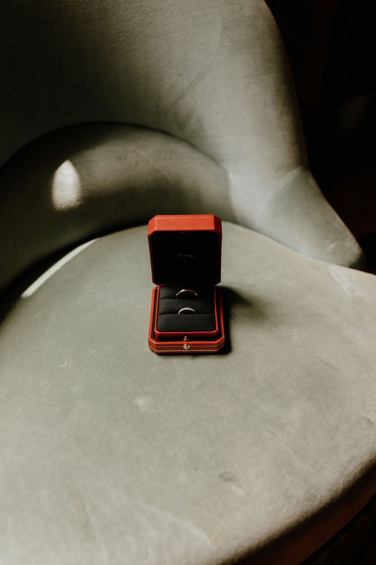 A series of minimalist black and white photos showing a small red jewelry box resting on a light surface.