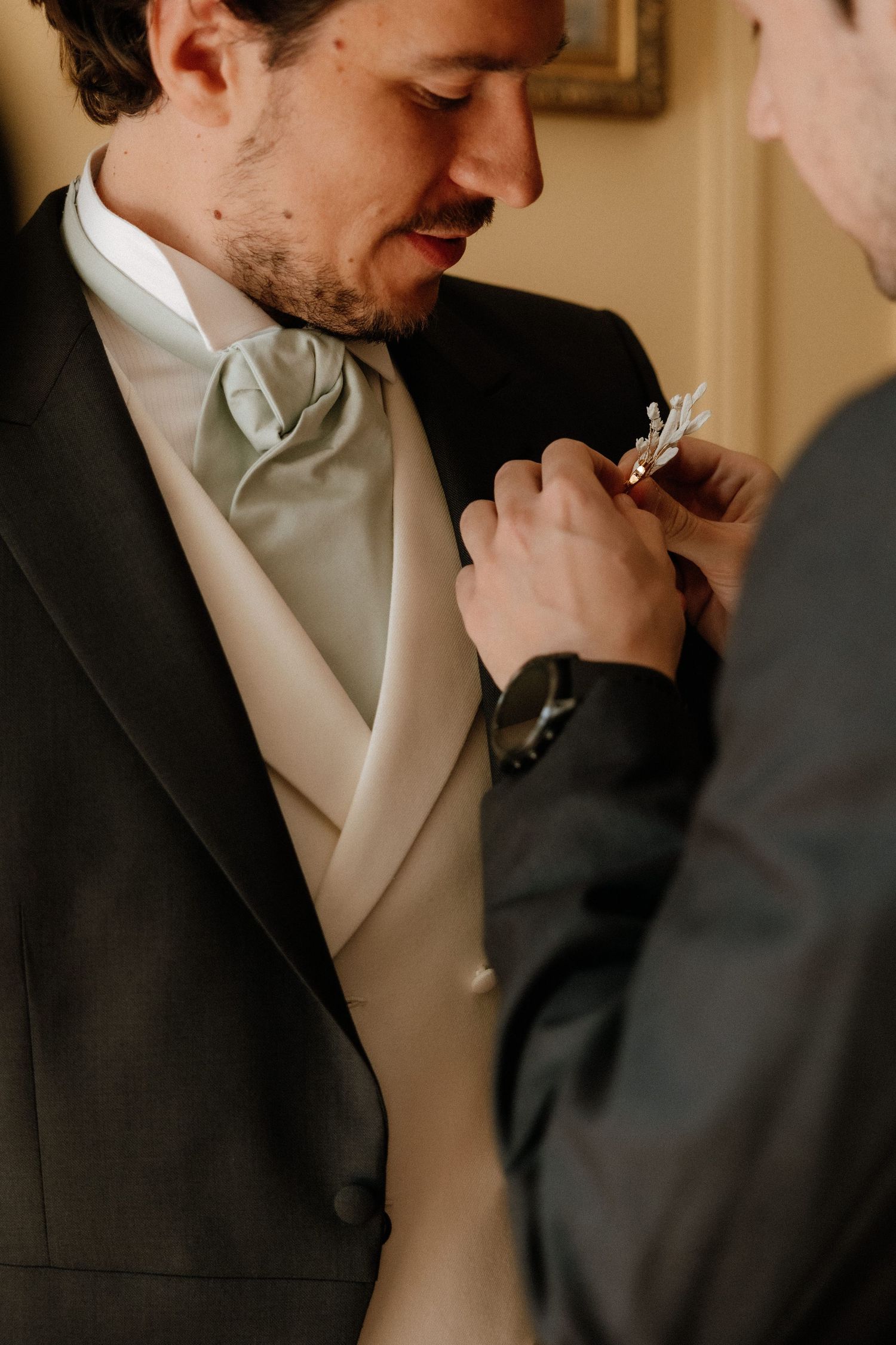 A sequence of formal wedding photos showing a groom adjusting his tie and boutonniere.