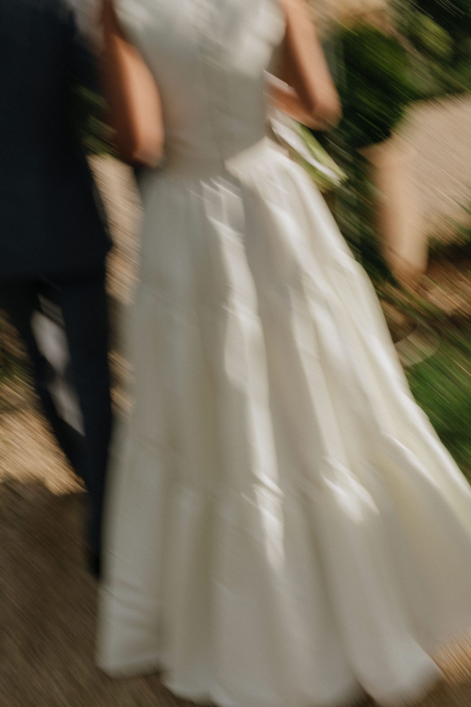 A sequence of blurred motion shots showing the flowing movement of a white wedding dress against a dark background.