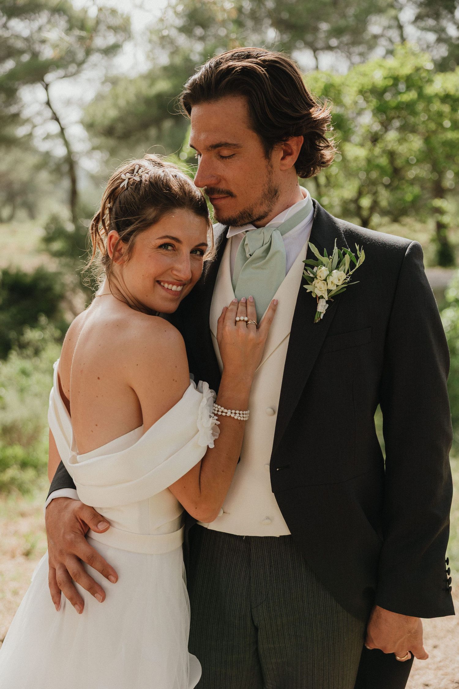 Romantic wedding couple shares intimate moments in a garden setting with soft natural lighting.