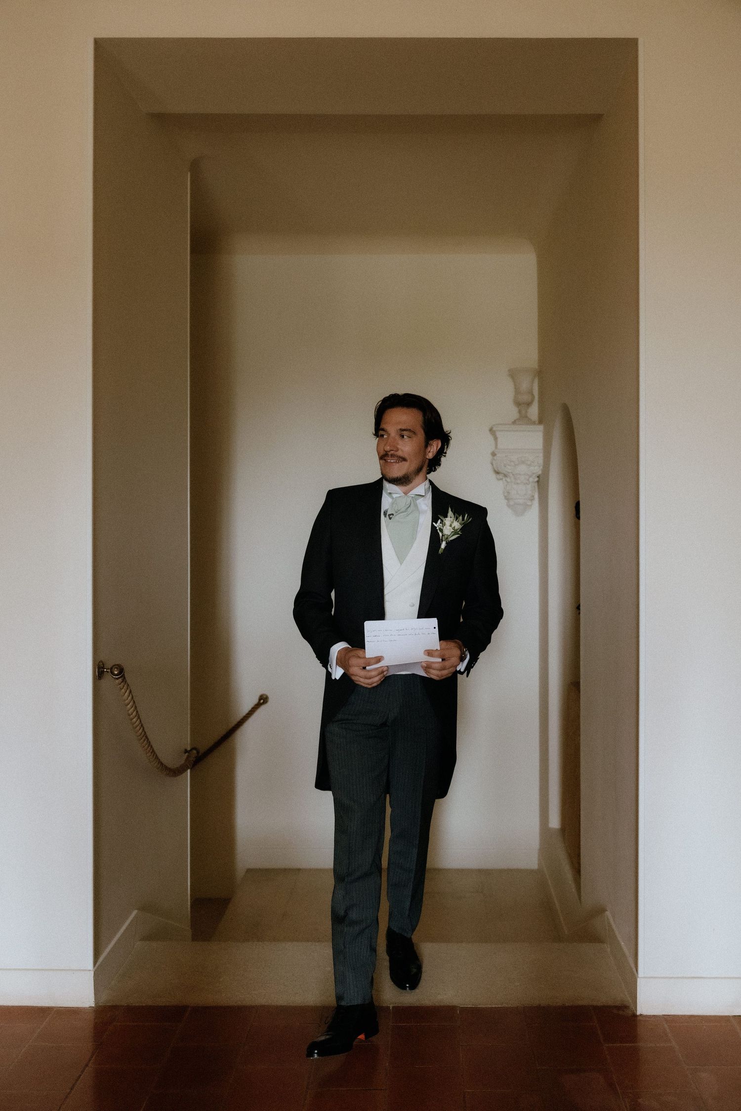 A sequence of artistic black and white photos showing a person in a suit walking through a minimalist hallway.