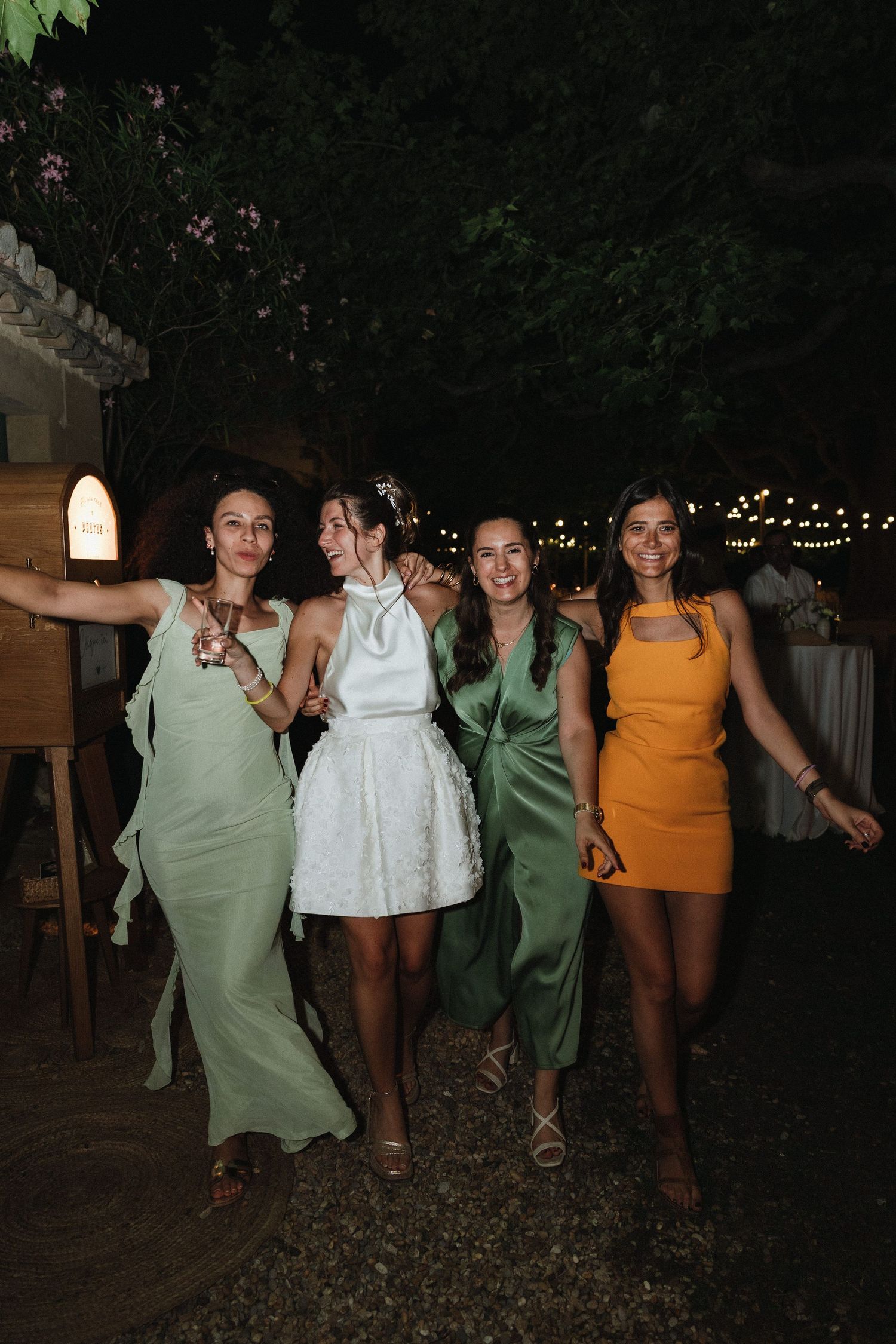 Group of wedding guests dancing together at an outdoor evening reception.