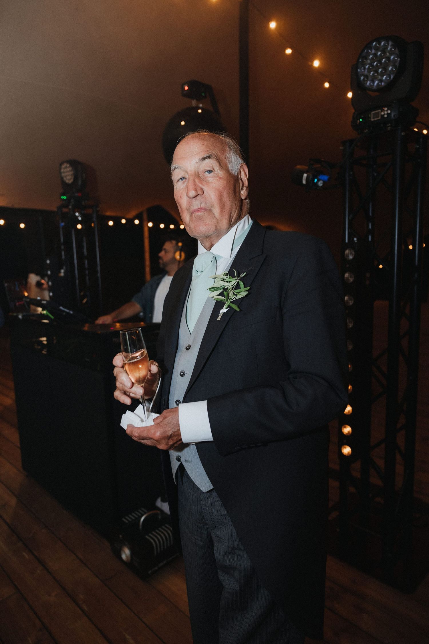 A person in formal attire enjoying refreshments at an evening reception.