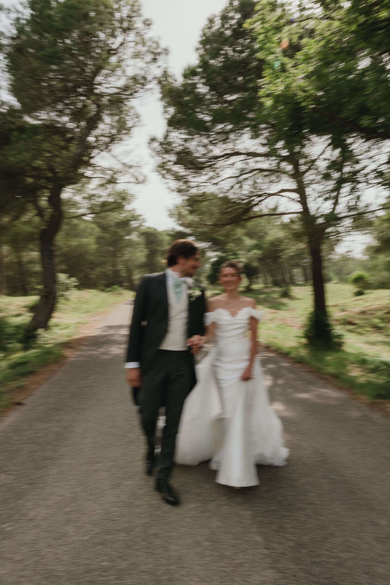 Wedding couple walking along a tree-lined path in romantic sequence shots.