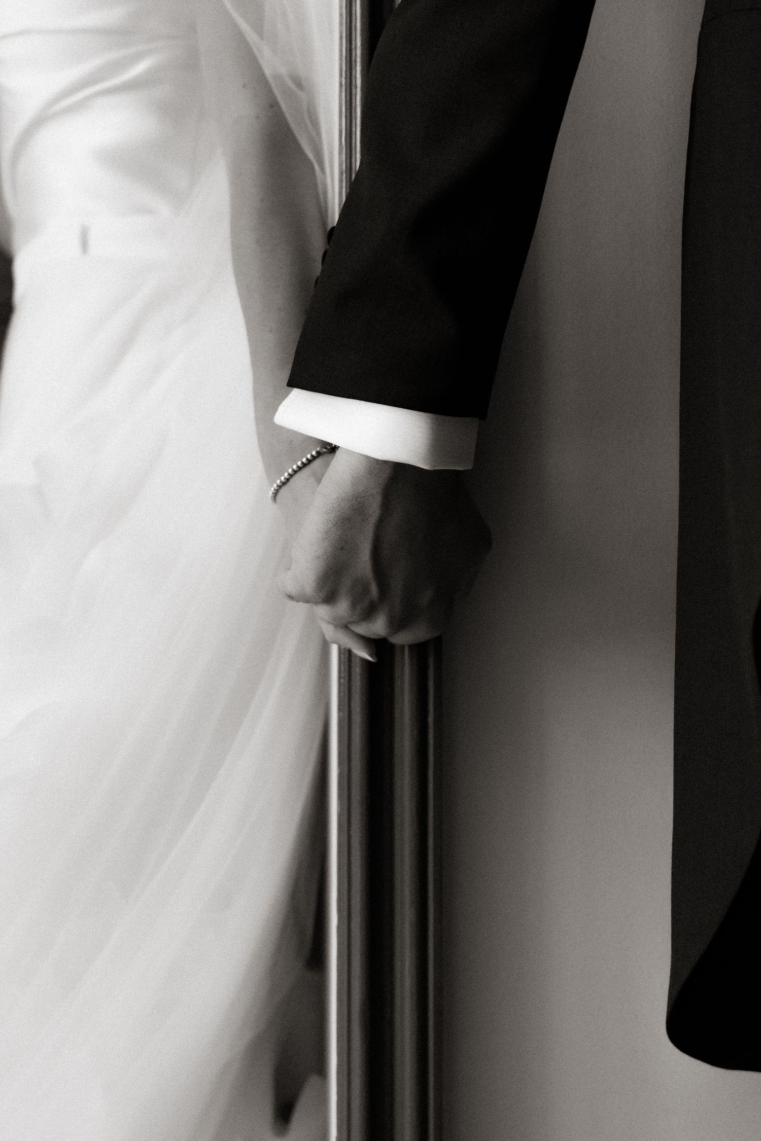 Close-up details of formal wedding attire in black and white.