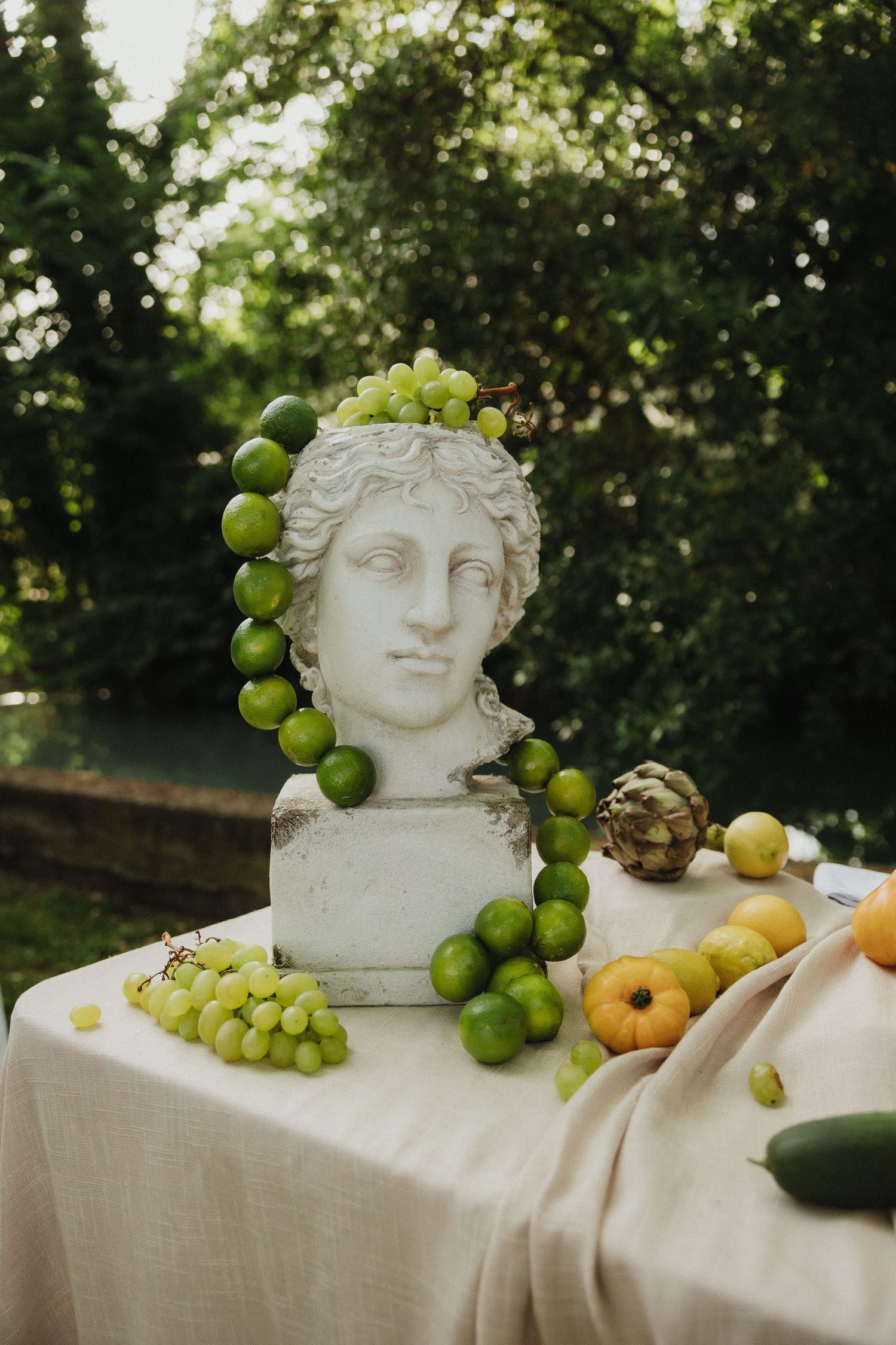 Classical stone bust decorates a wedding table with fresh fruits and elegant table settings.