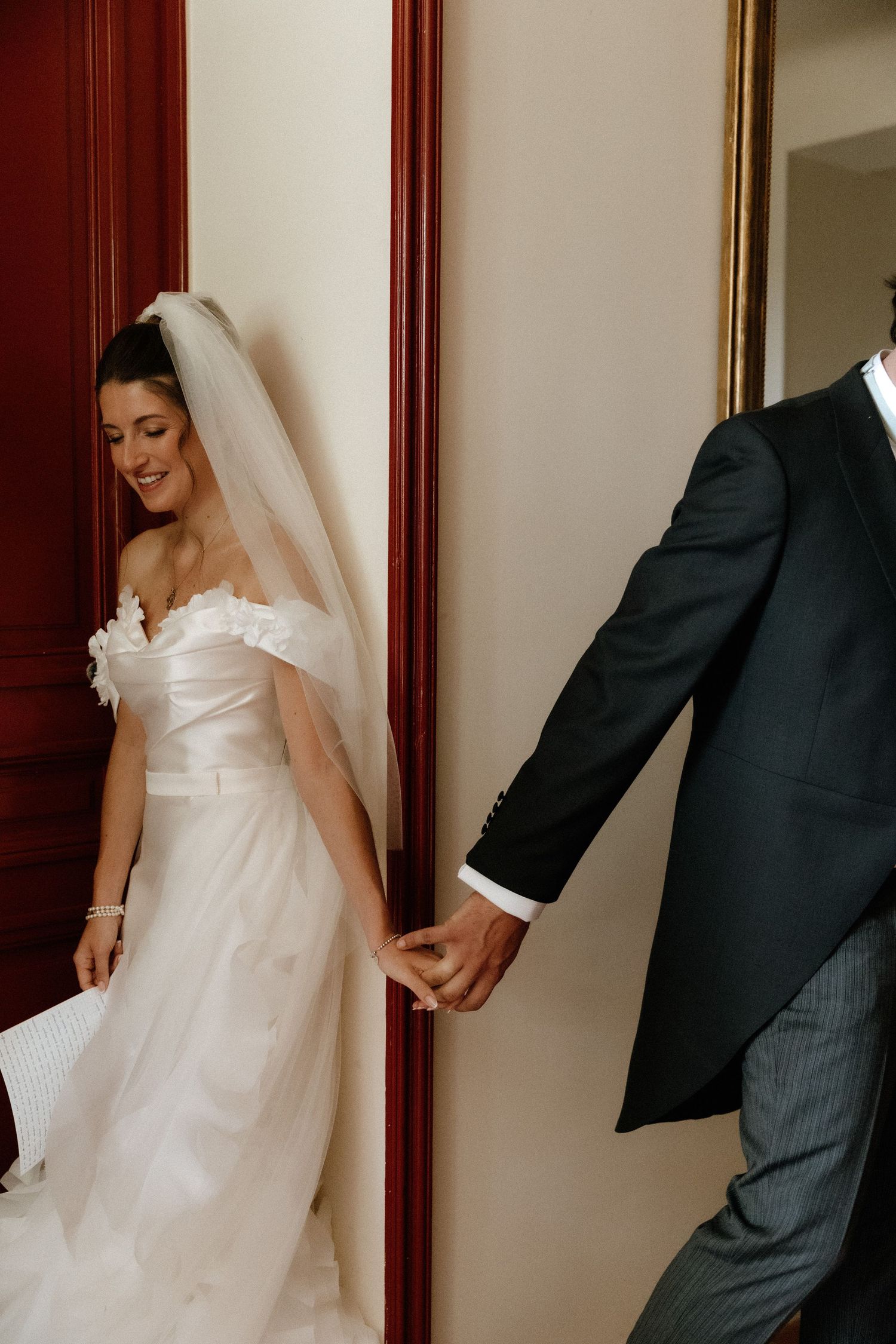 A romantic first look moment between newlyweds with the bride in white and groom in dark suit.