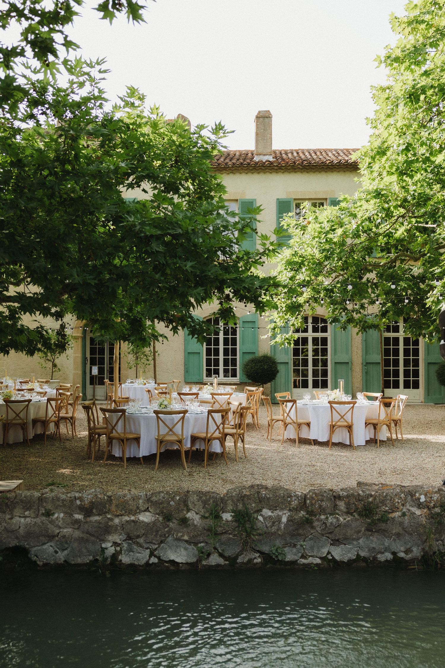 Waterfront wedding reception venue with elegant table settings and natural stone architecture.