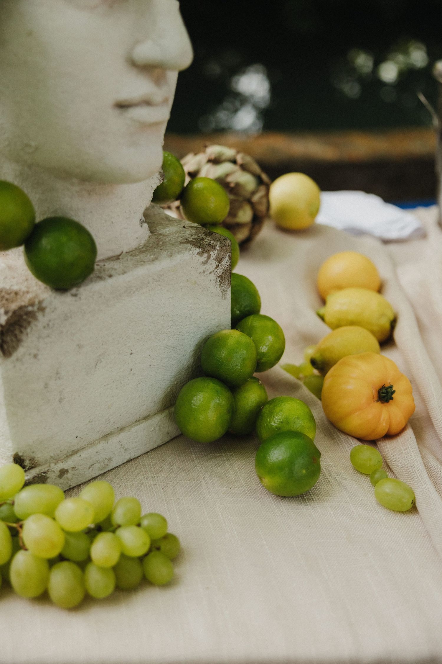 Still life composition of fresh citrus fruits and grapes arranged on a white surface.