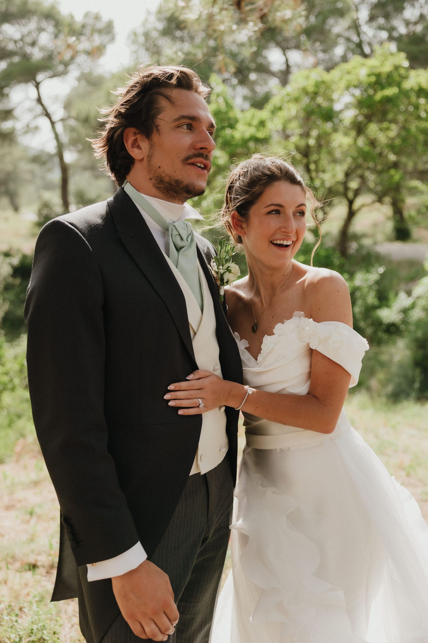 Candid moments of joy between newlyweds in an outdoor garden setting.