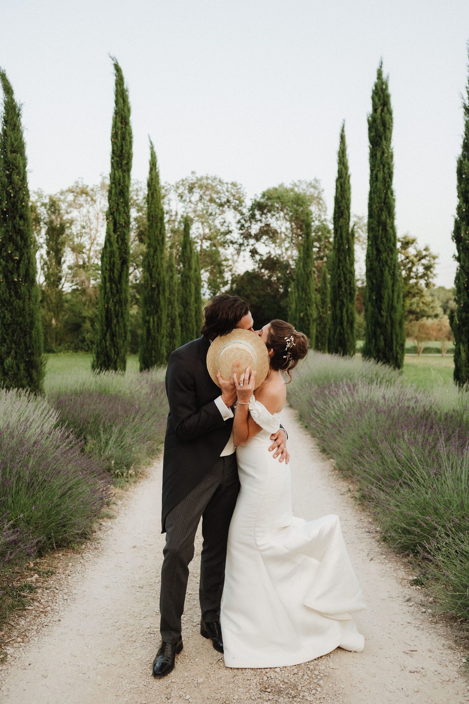 Romantic wedding photos along a cypress and lavender-lined path in golden light.