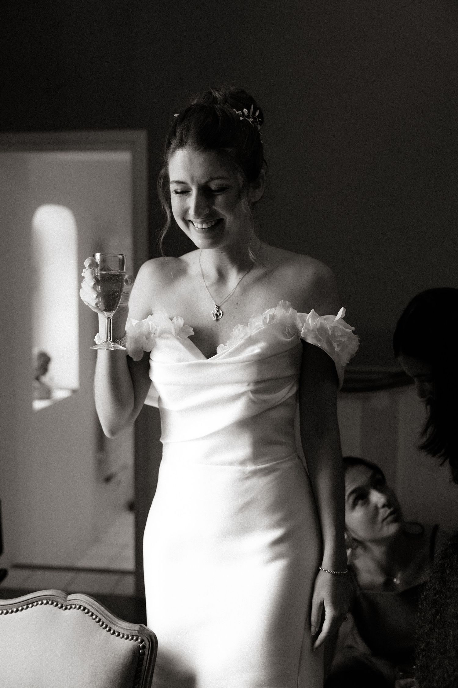 Elegant white wedding dress details shown in dramatic black and white photography.