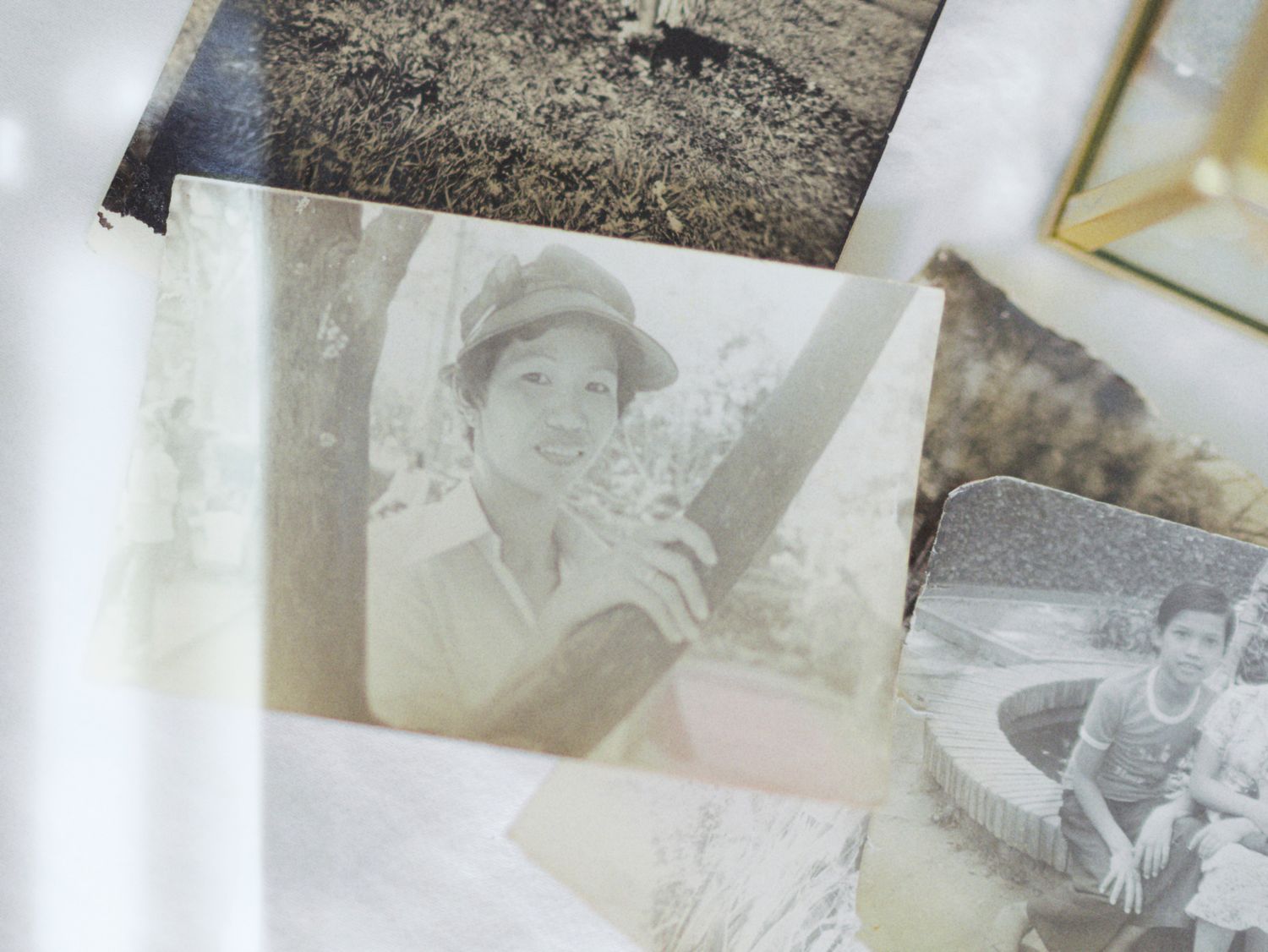 A vintage black and white photograph showing old photo prints laid out on a light surface.