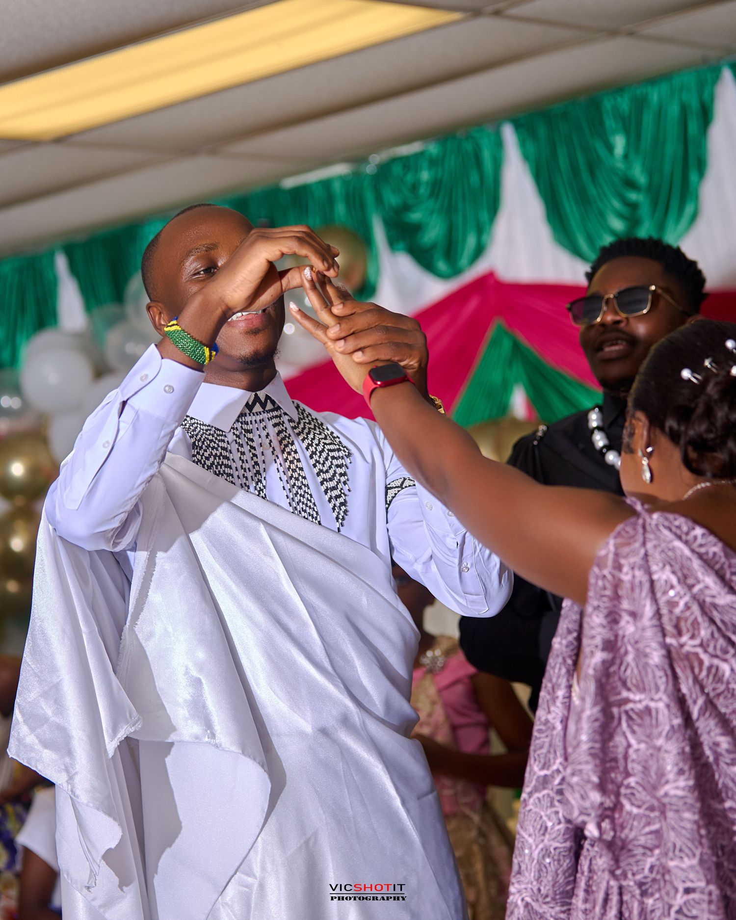 Wedding guests sharing emotional moments during ceremony with white and green decor.