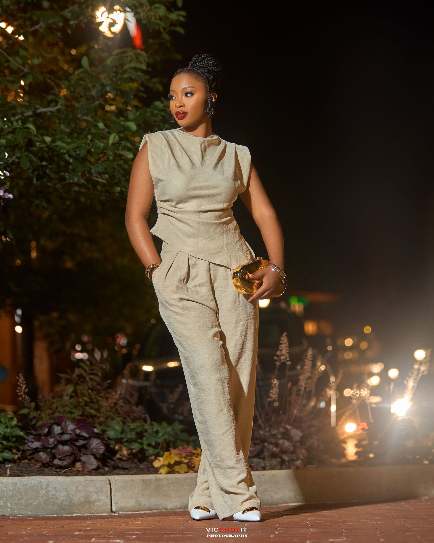 Urban nighttime fashion shoot featuring khaki jumpsuit and sneakers.