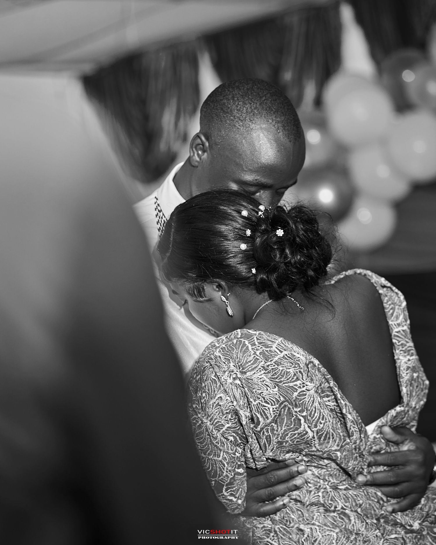 Black and white photo capturing intimate wedding ceremony moment.