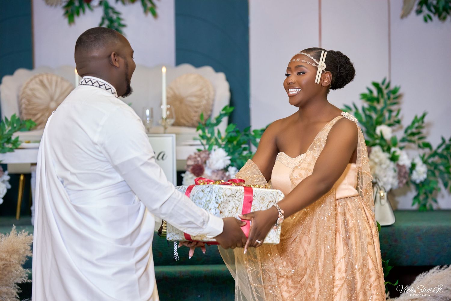 Wedding guests celebrating with hugs and gift exchanges at an elegant reception.
