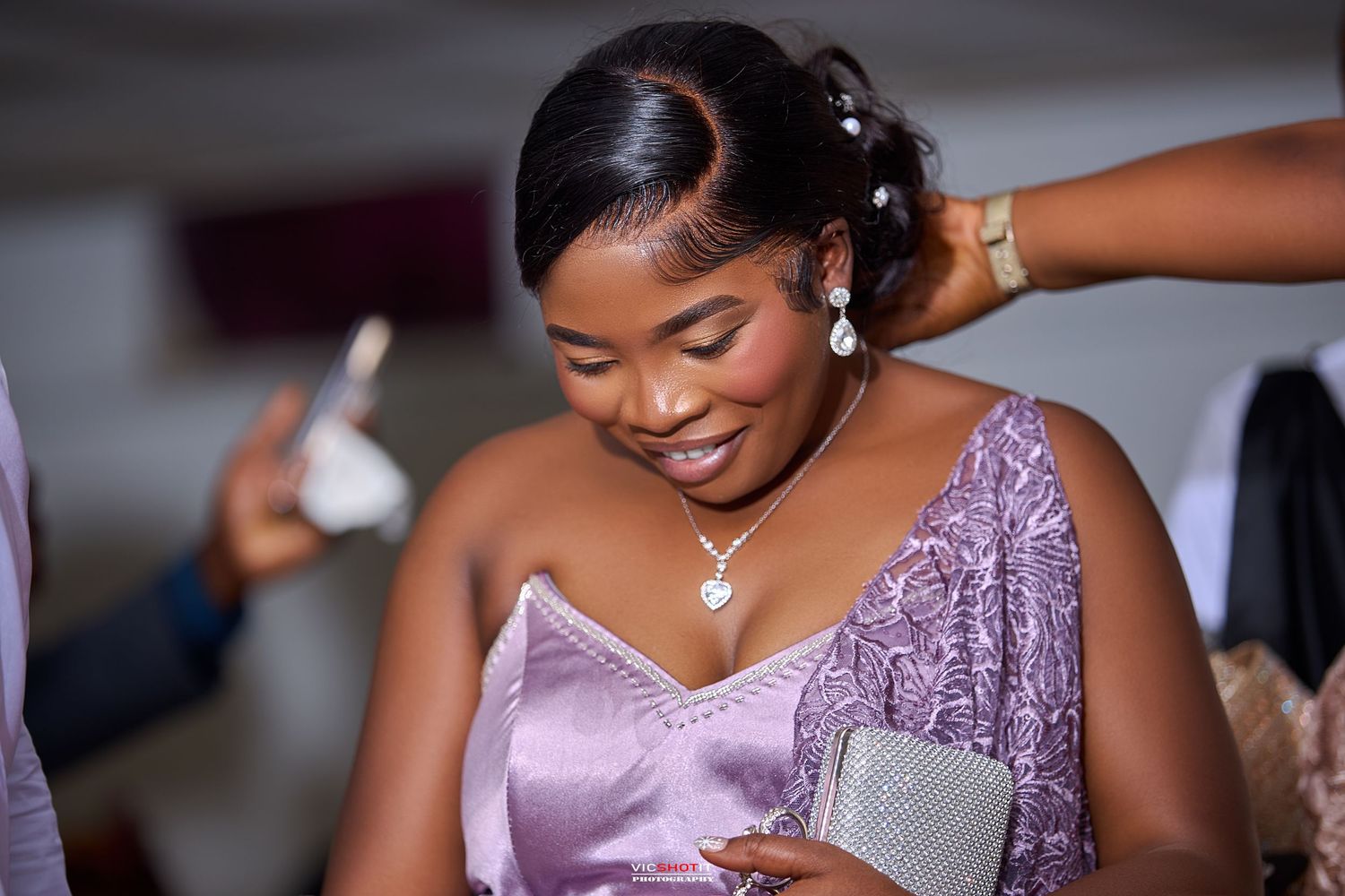 Woman in purple formal dress smiling during outdoor portrait session.