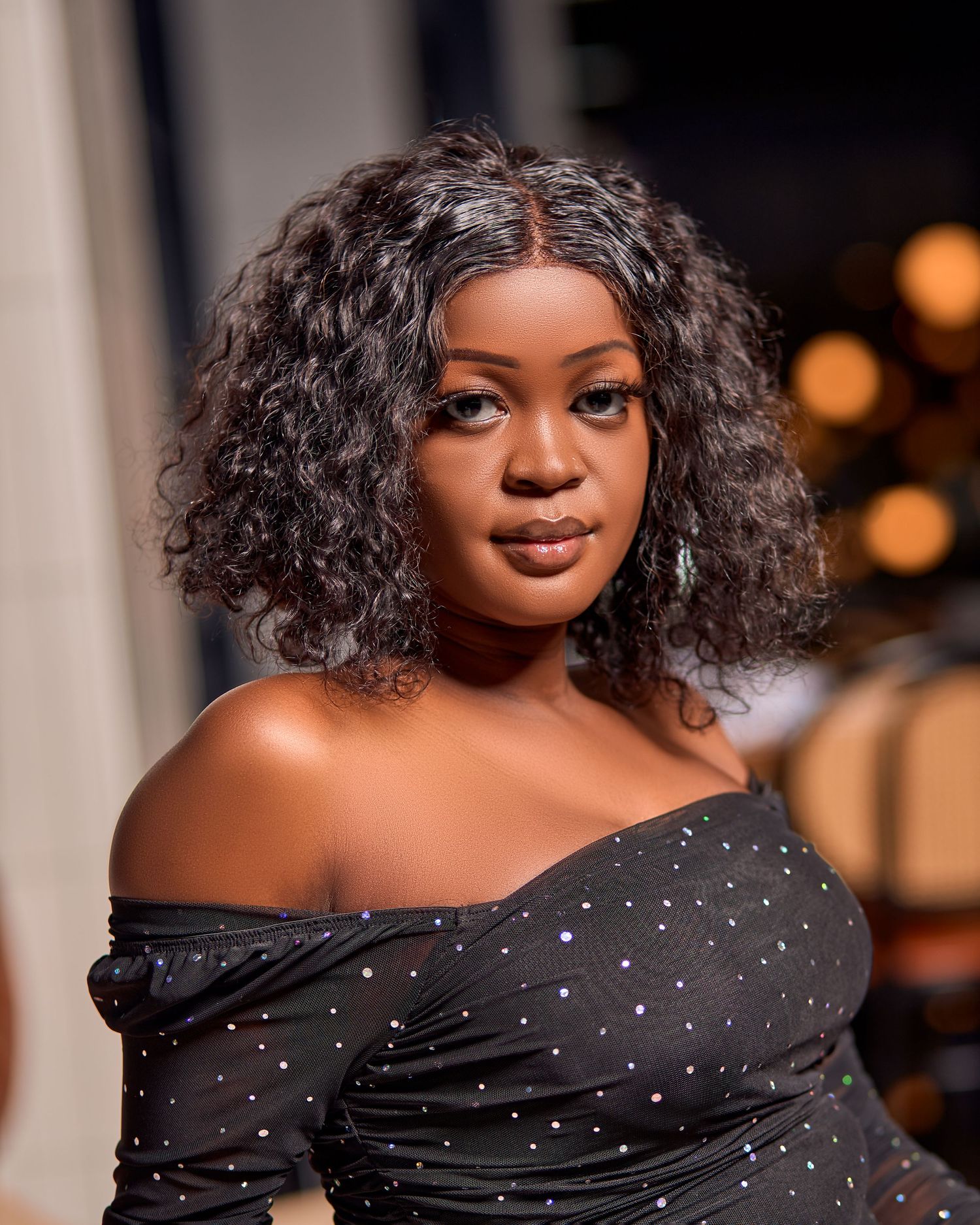Elegant portrait featuring a sparkly off-shoulder black dress with glamorous evening makeup.