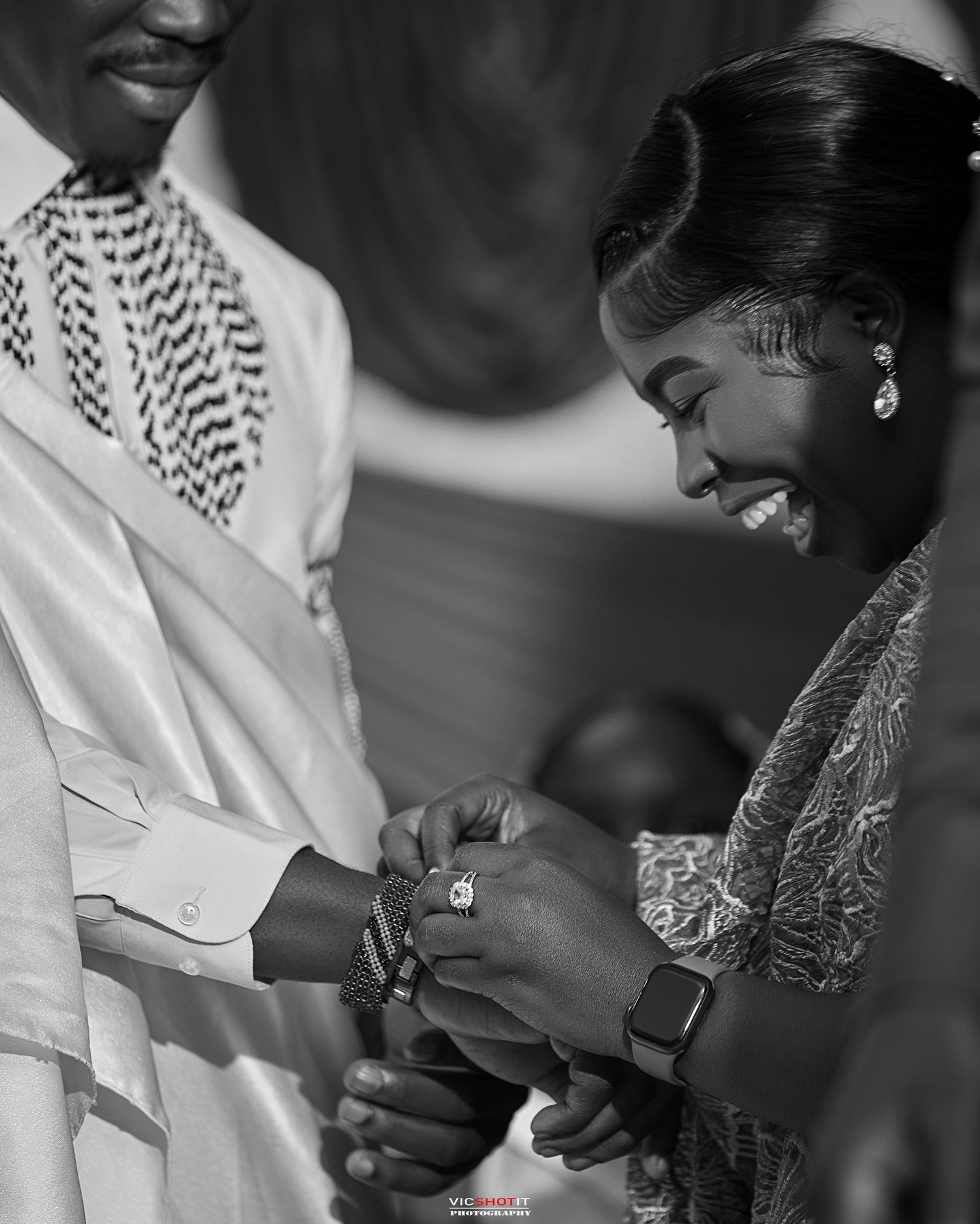 Black and white candid photo of wedding ceremony interaction.