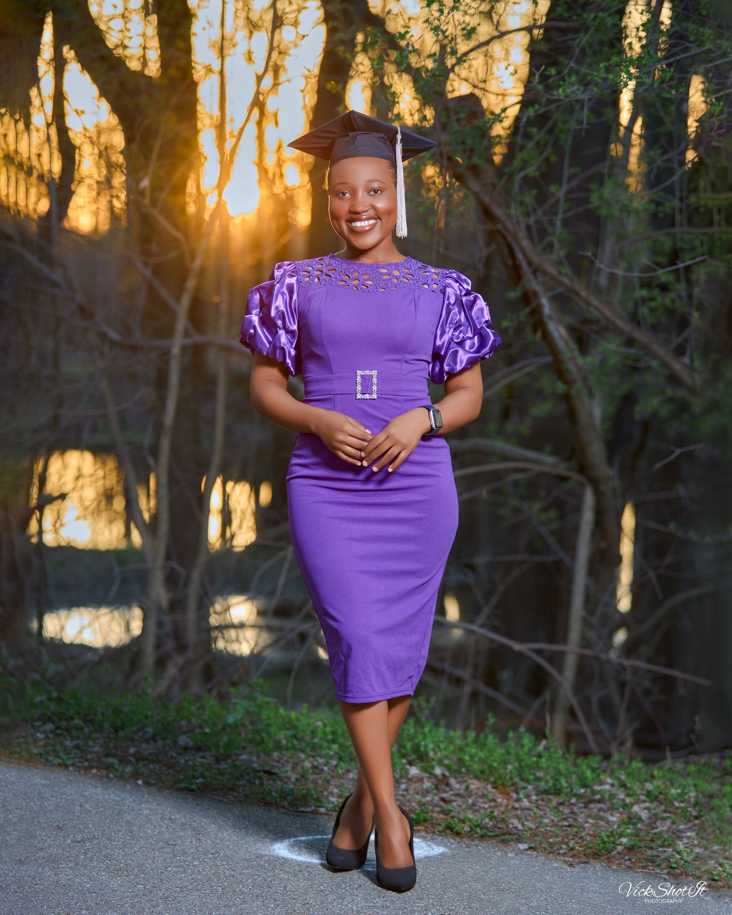 A purple dress with puff sleeves photographed at sunset with trees in the background.