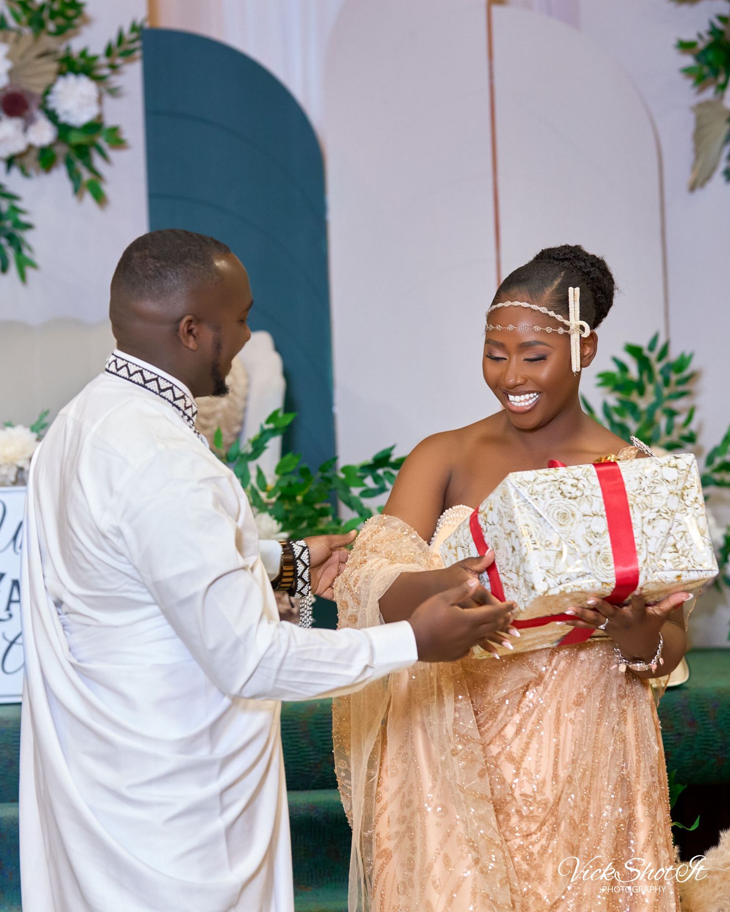 Wedding guests exchanging gifts and hugging during a celebration.