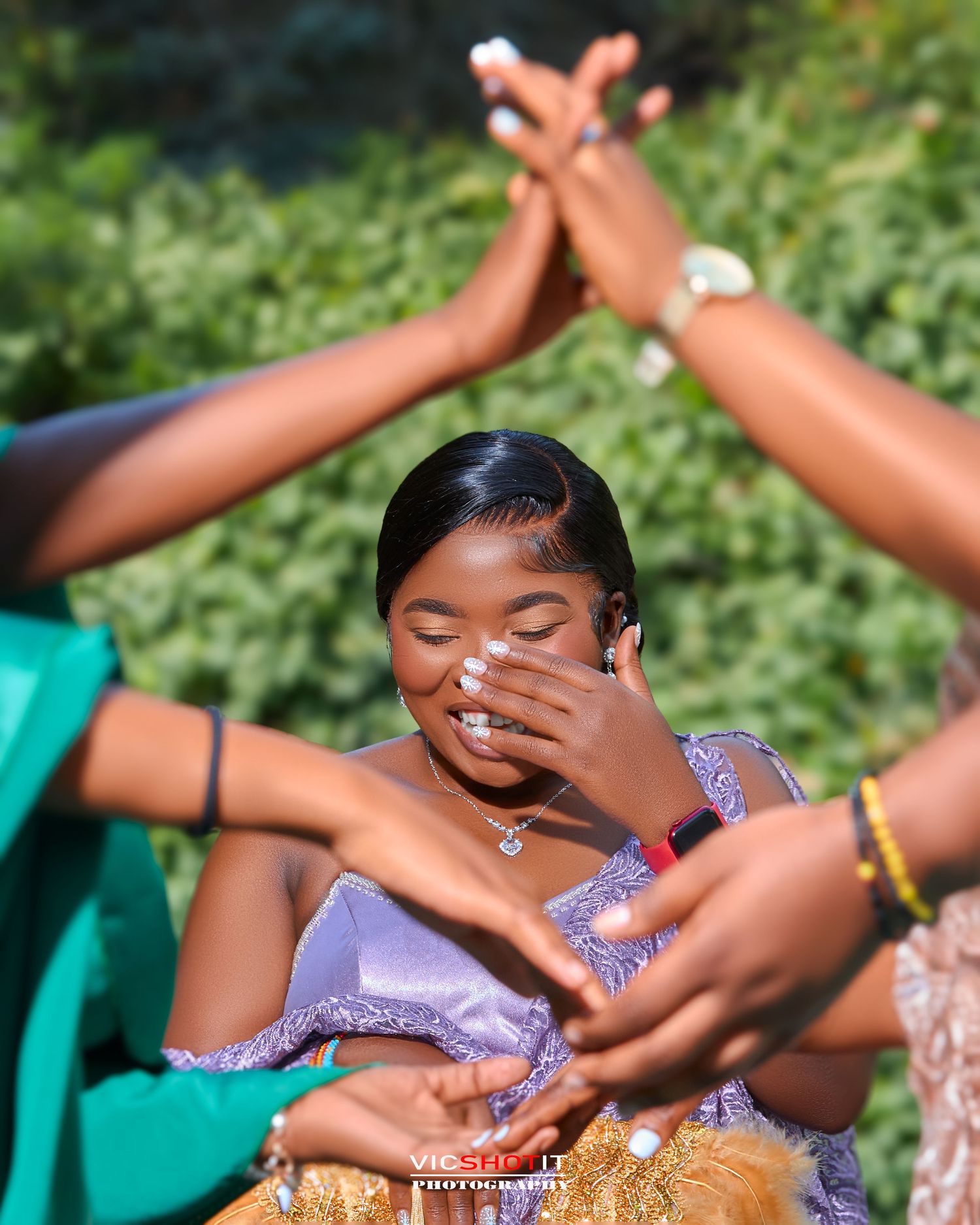 Woman in purple dress laughing joyfully during outdoor photoshoot with friends.