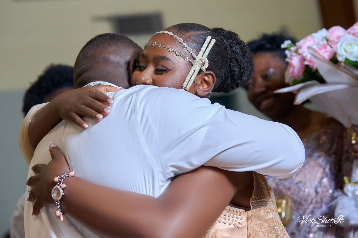 Guests sharing emotional embraces during a wedding celebration.