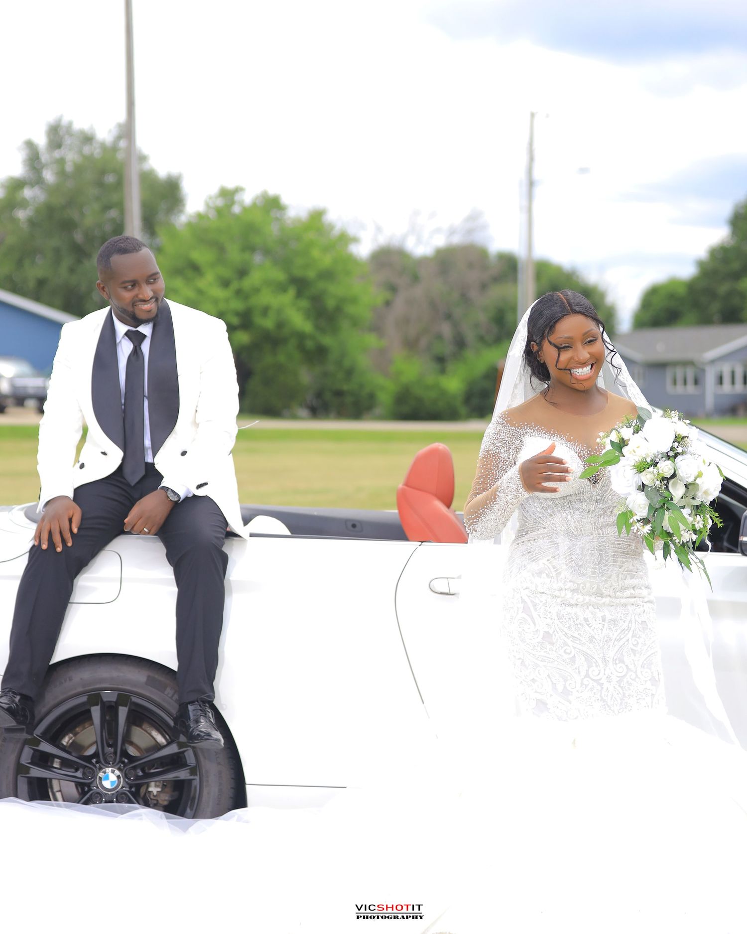 Wedding photo session with classic white and black attire in an outdoor setting.