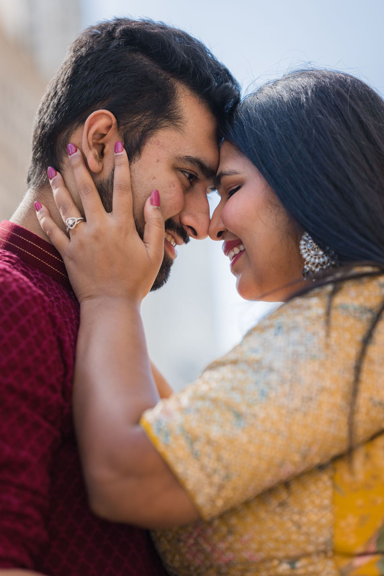 A close-up romantic moment showing traditional Indian wedding jewelry and attire.