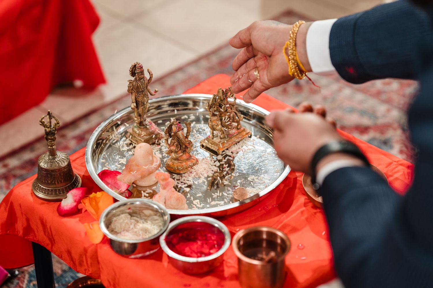 Traditional Indian ceremony items displayed on silver tray with red decorative cloth.