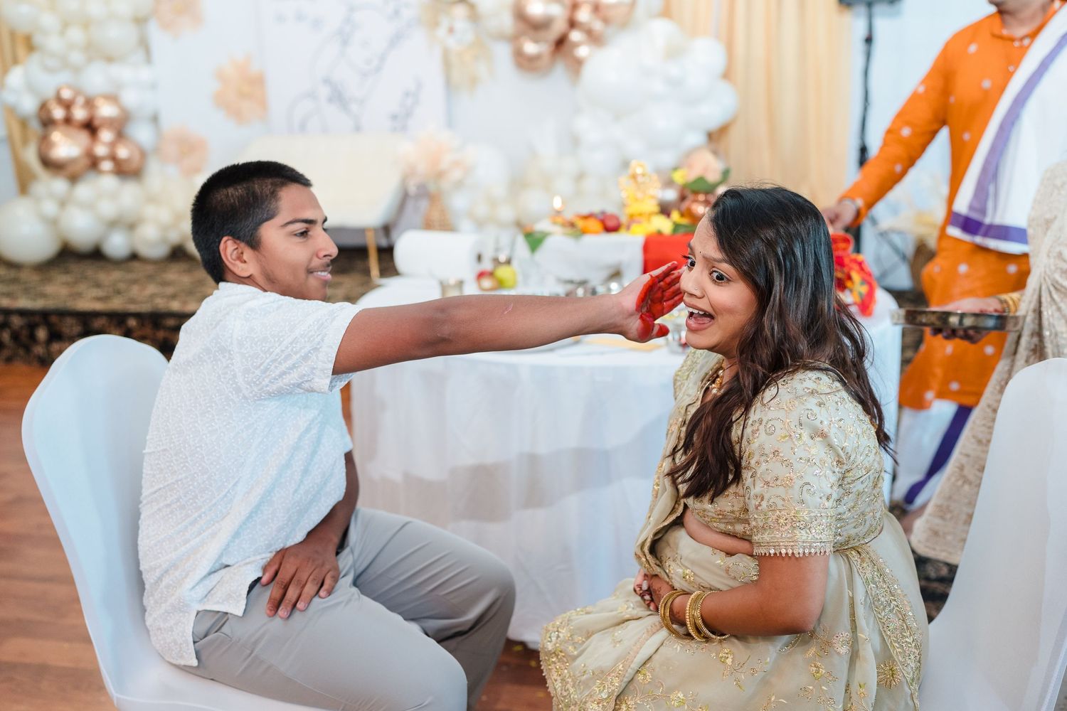 A festive moment during an Indian wedding ceremony with vibrant balloon decor and traditional attire.