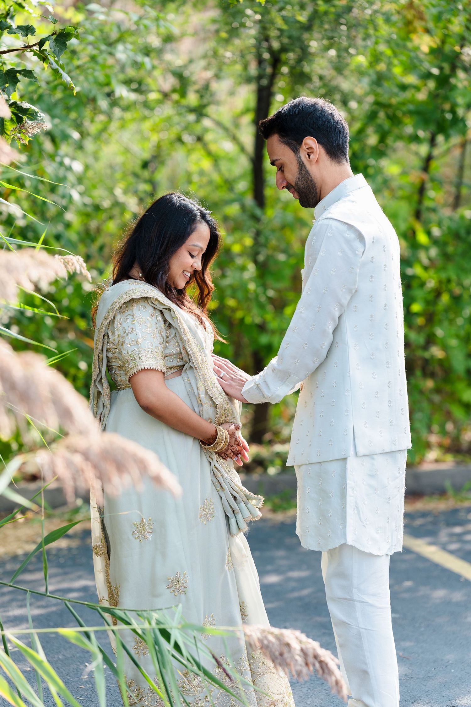 Outdoor maternity photoshoot with natural greenery and soft lighting.