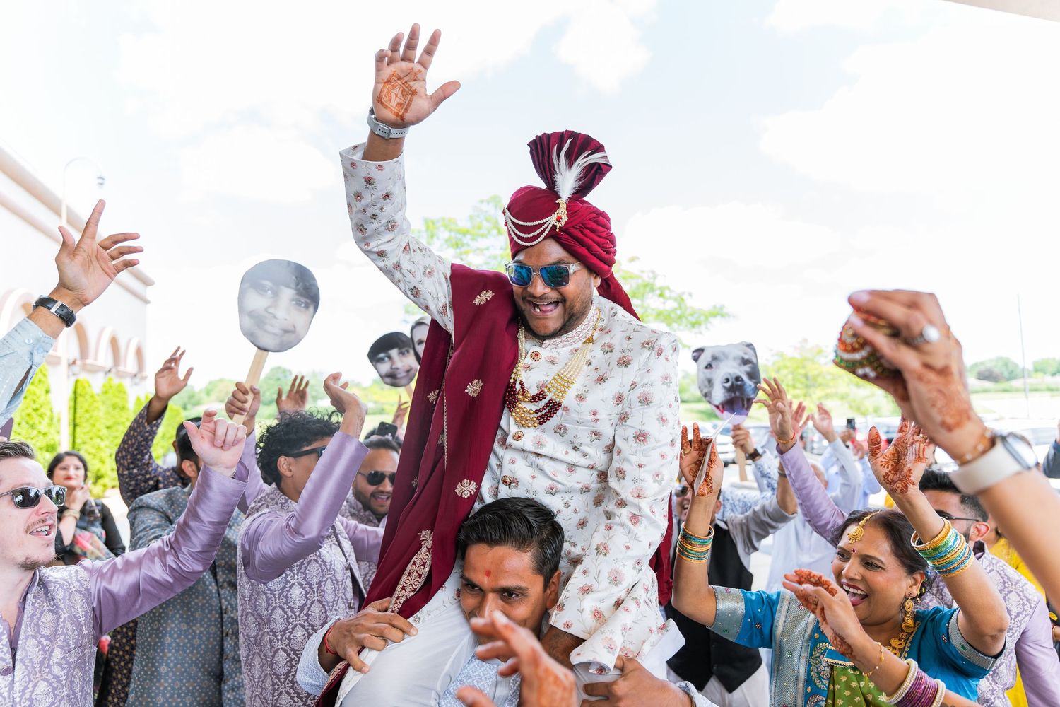 Joyous crowd celebrating at a traditional Indian wedding baraat procession.