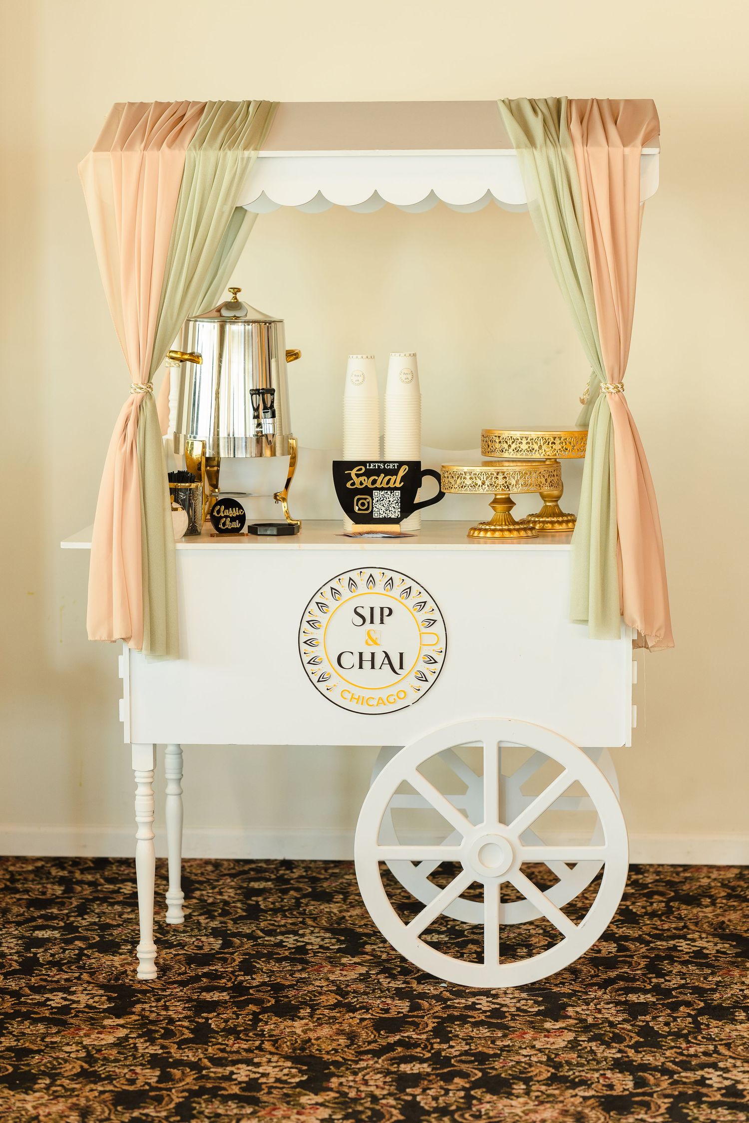 Vintage-style chai cart with pastel curtains and decorative beverage dispensers.