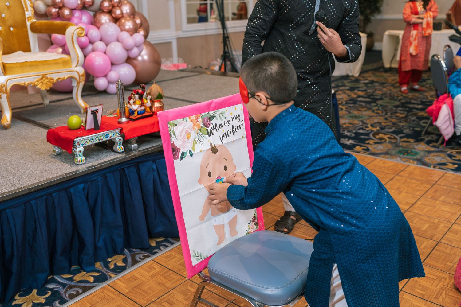 Child interacting with a pink photo frame at an event setup.