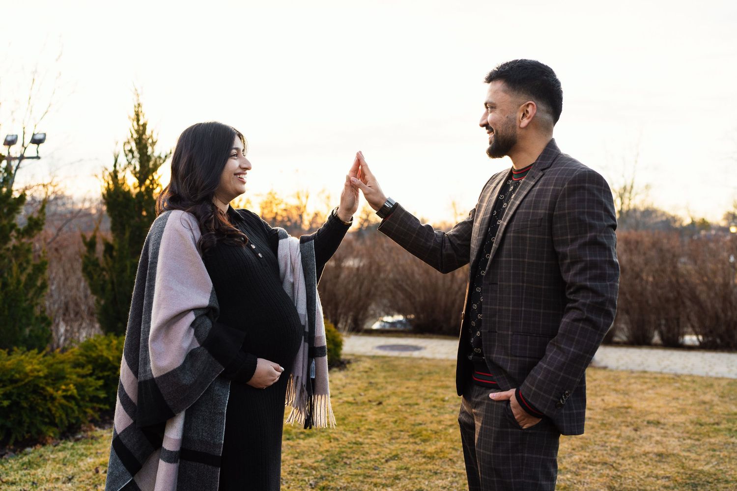 Two people sharing a celebratory high five outdoors during golden hour.