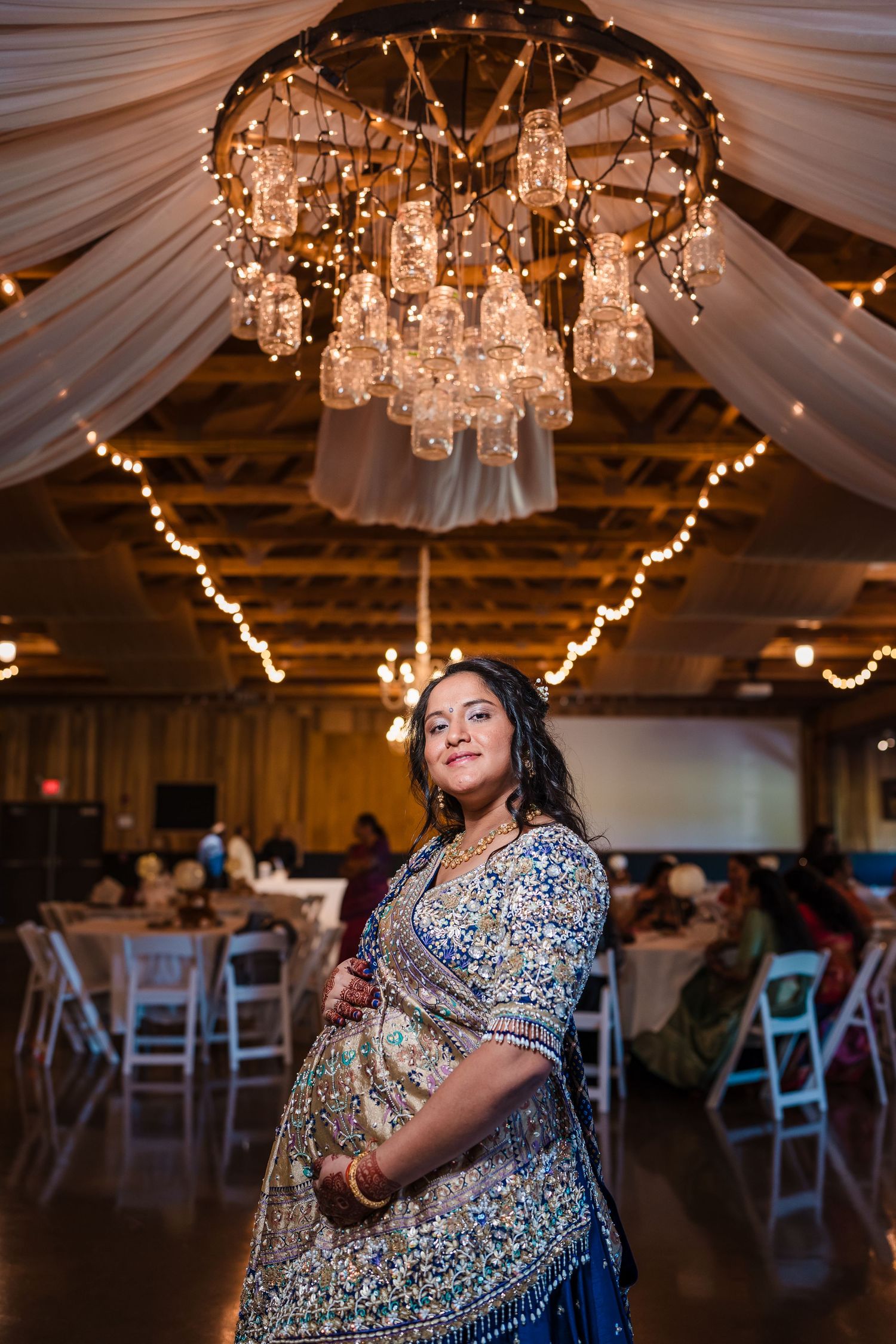 Elegant reception venue with crystal chandelier and white fabric draping creating a romantic atmosphere.