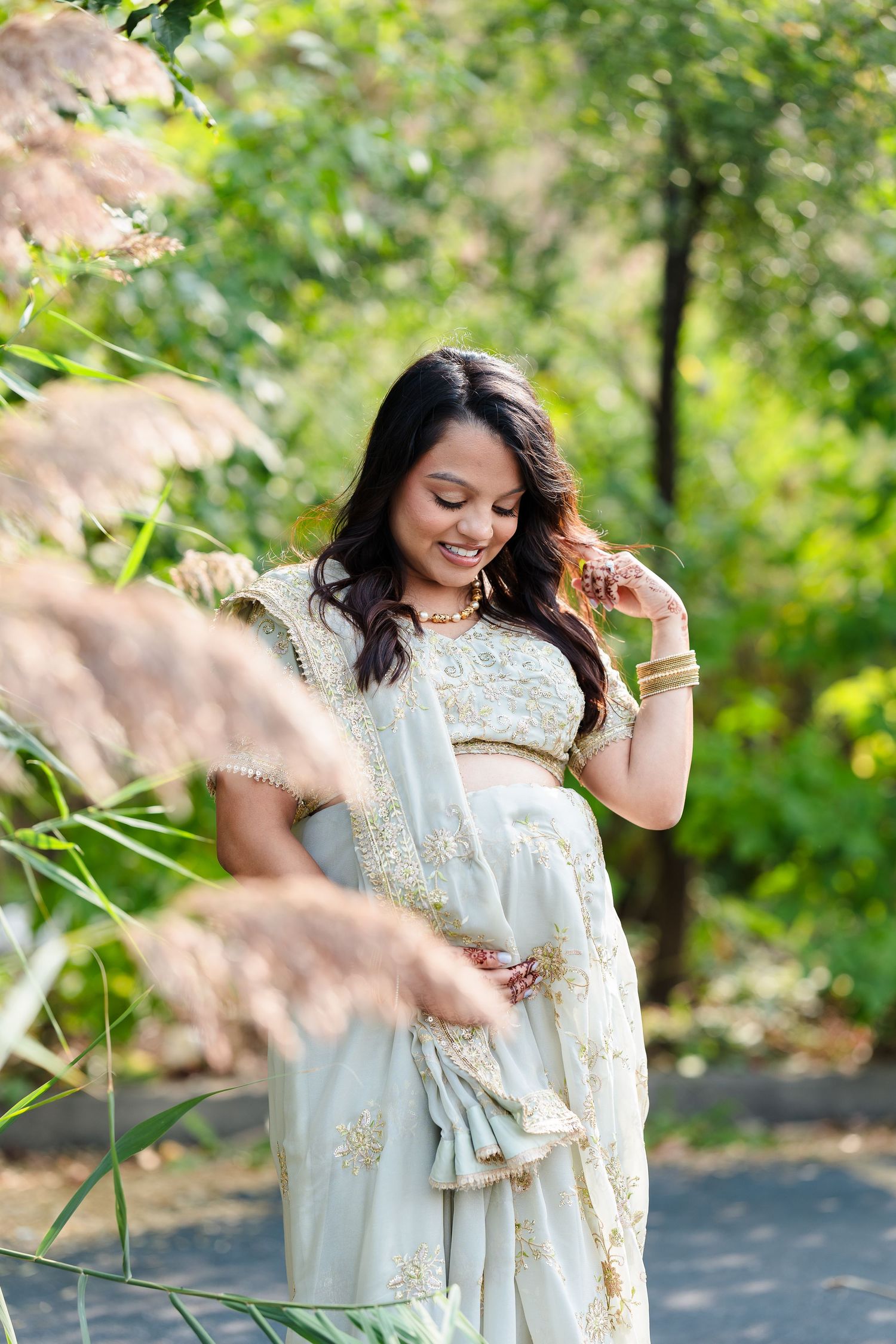 Ethereal maternity portrait in a lush garden setting with soft natural lighting.