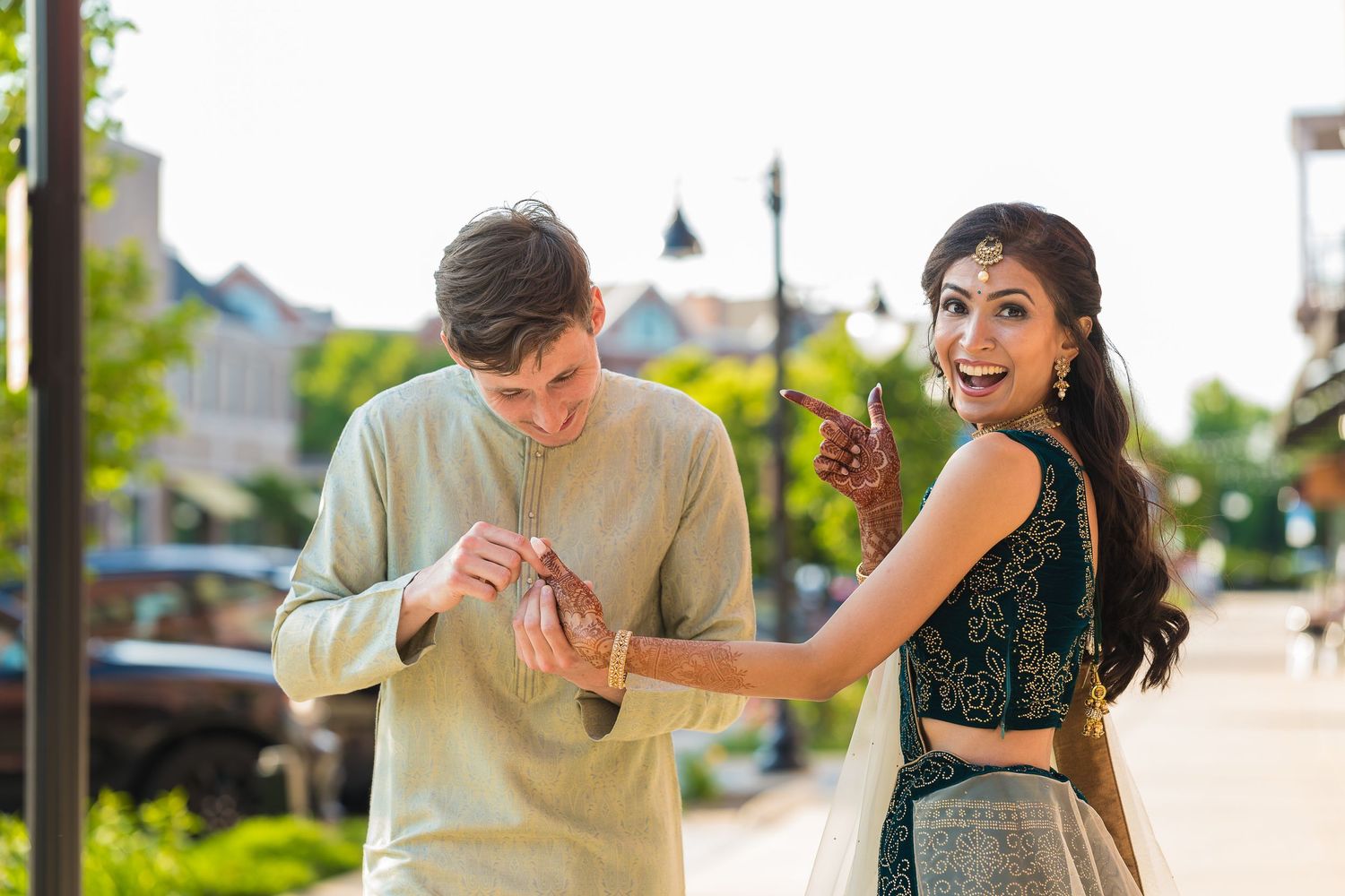 Playful couple dancing together on urban sidewalk during sunset.
