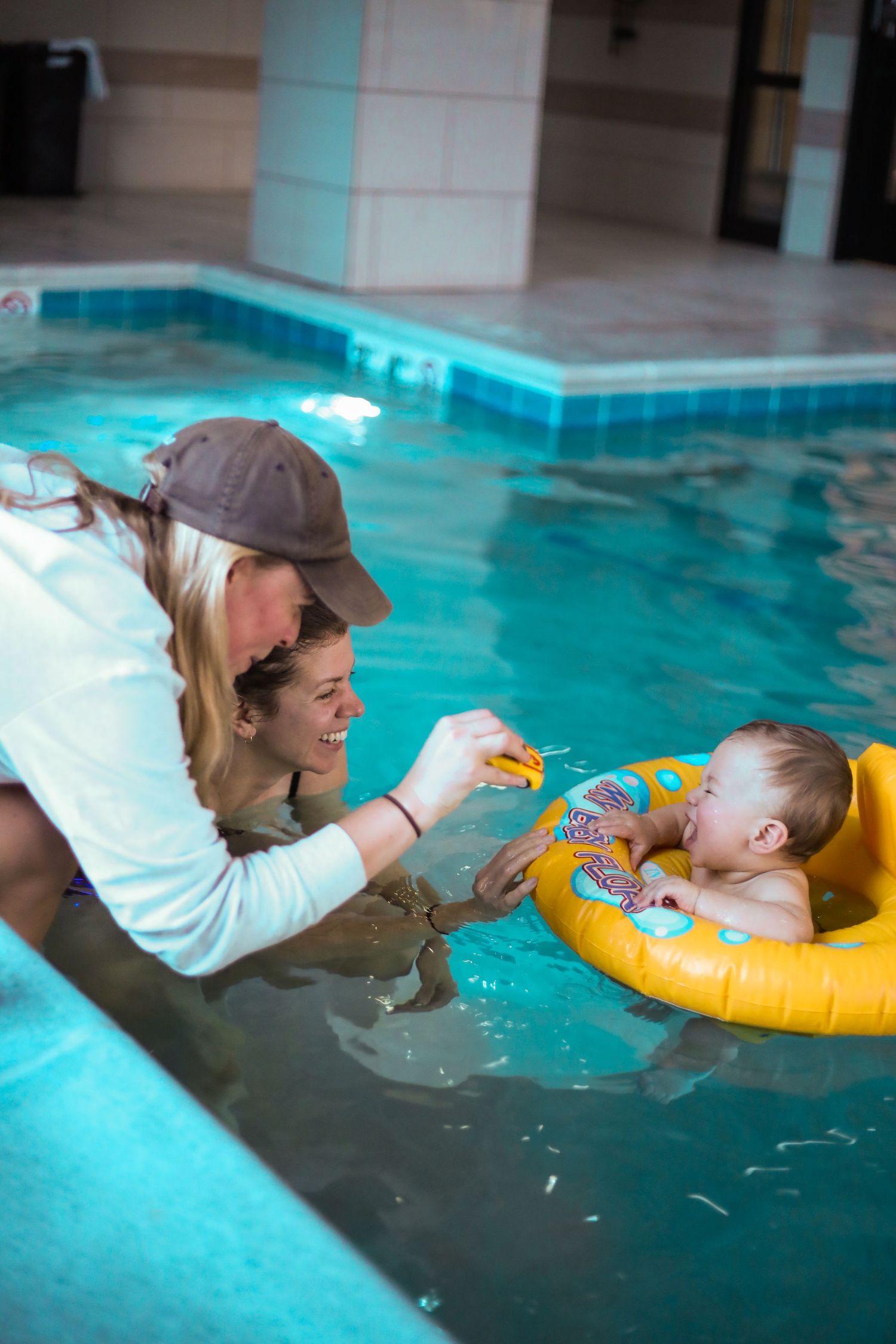 Two women with their baby, playing in a pool