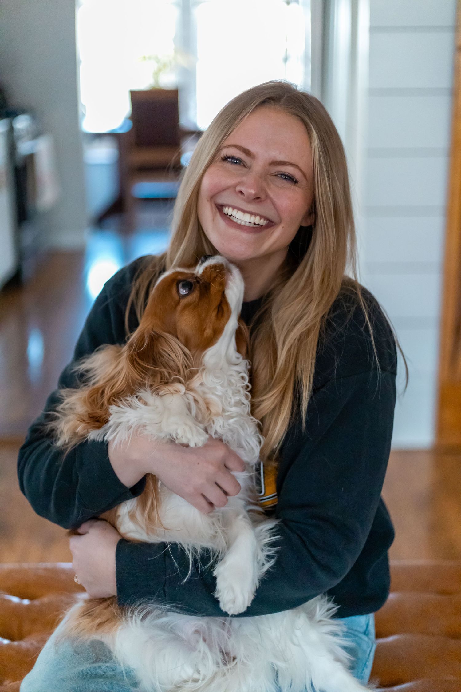 Madison holding her dog, who is kissing her chin