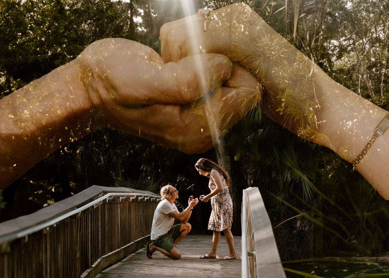 Romantic outdoor proposal on a bridge with glittery double-exposed hands forming a heart above the couple.