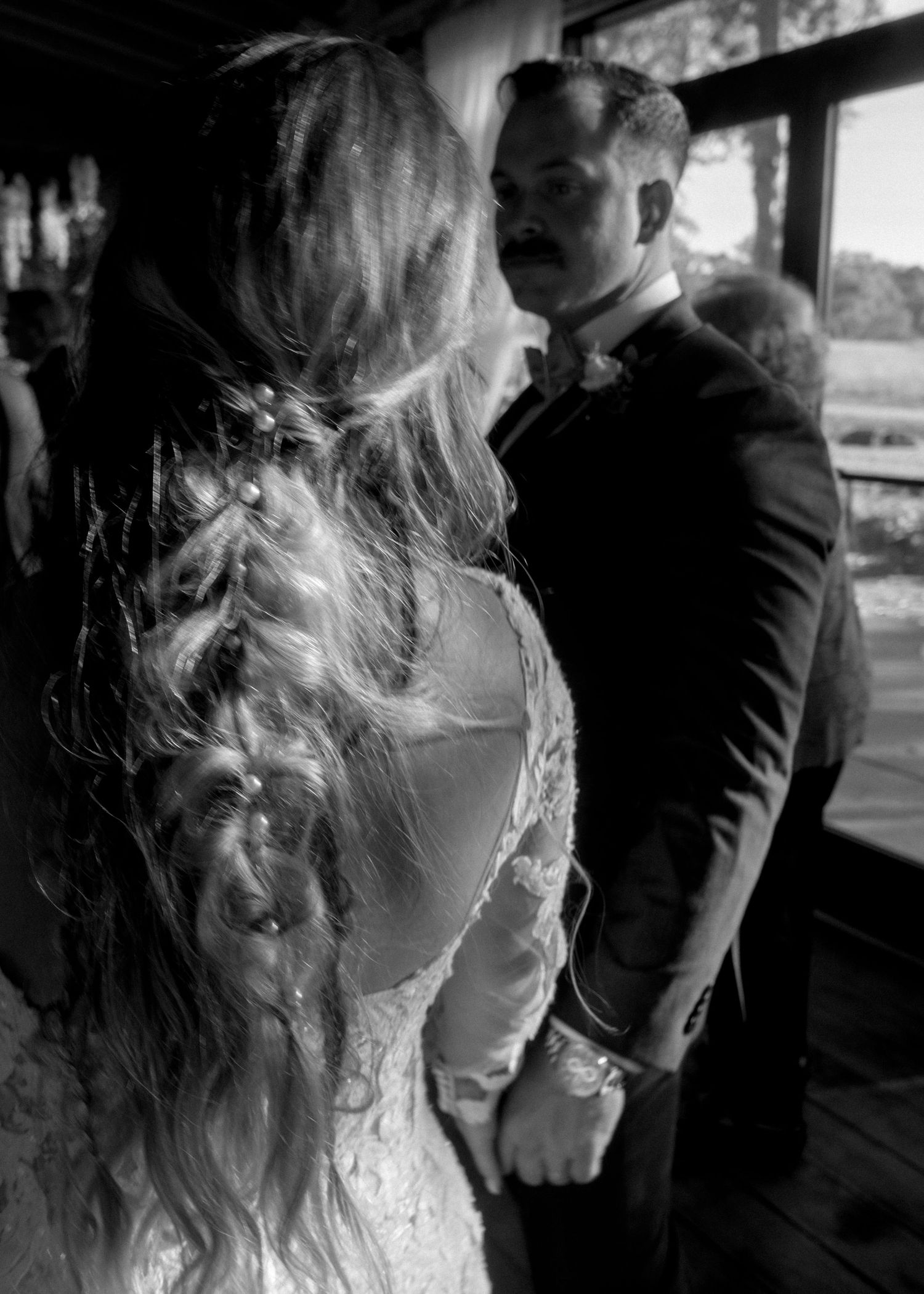 Black and white photo of bride and groom sharing an intimate moment during wedding ceremony.