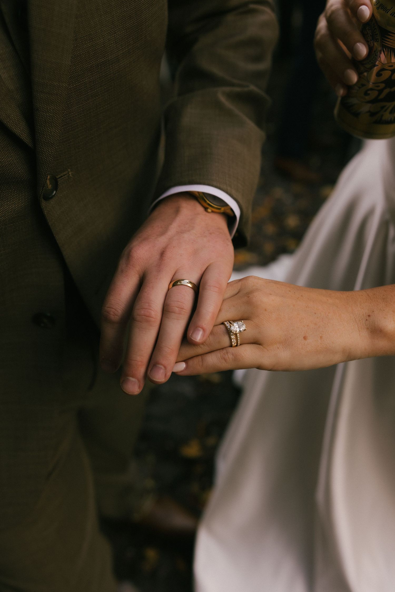 Close-up photo of wedding rings on hands showing intimate details of a couple's wedding jewelry.