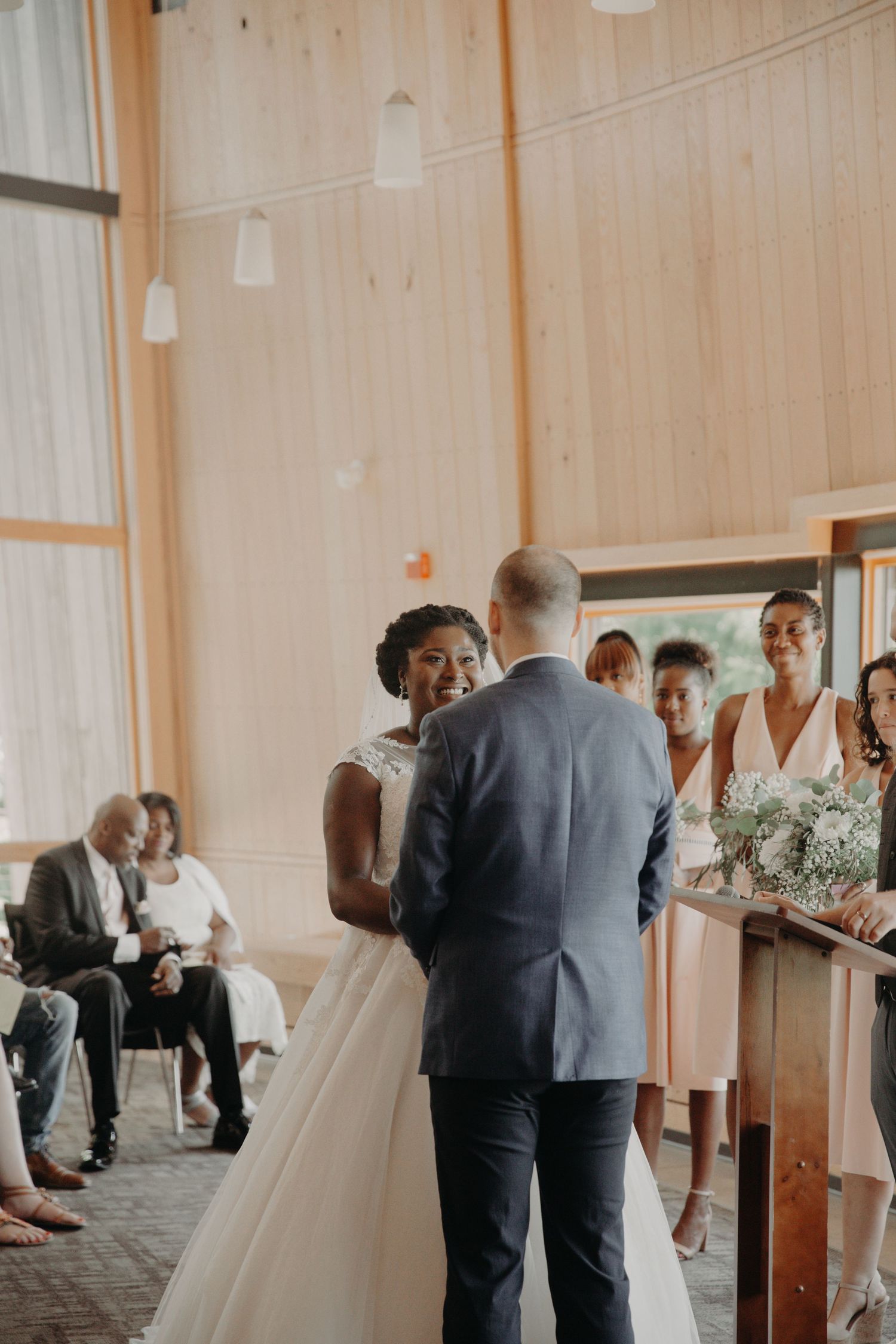 Intimate moment during wedding ceremony with couple exchanging vows surrounded by wedding party.