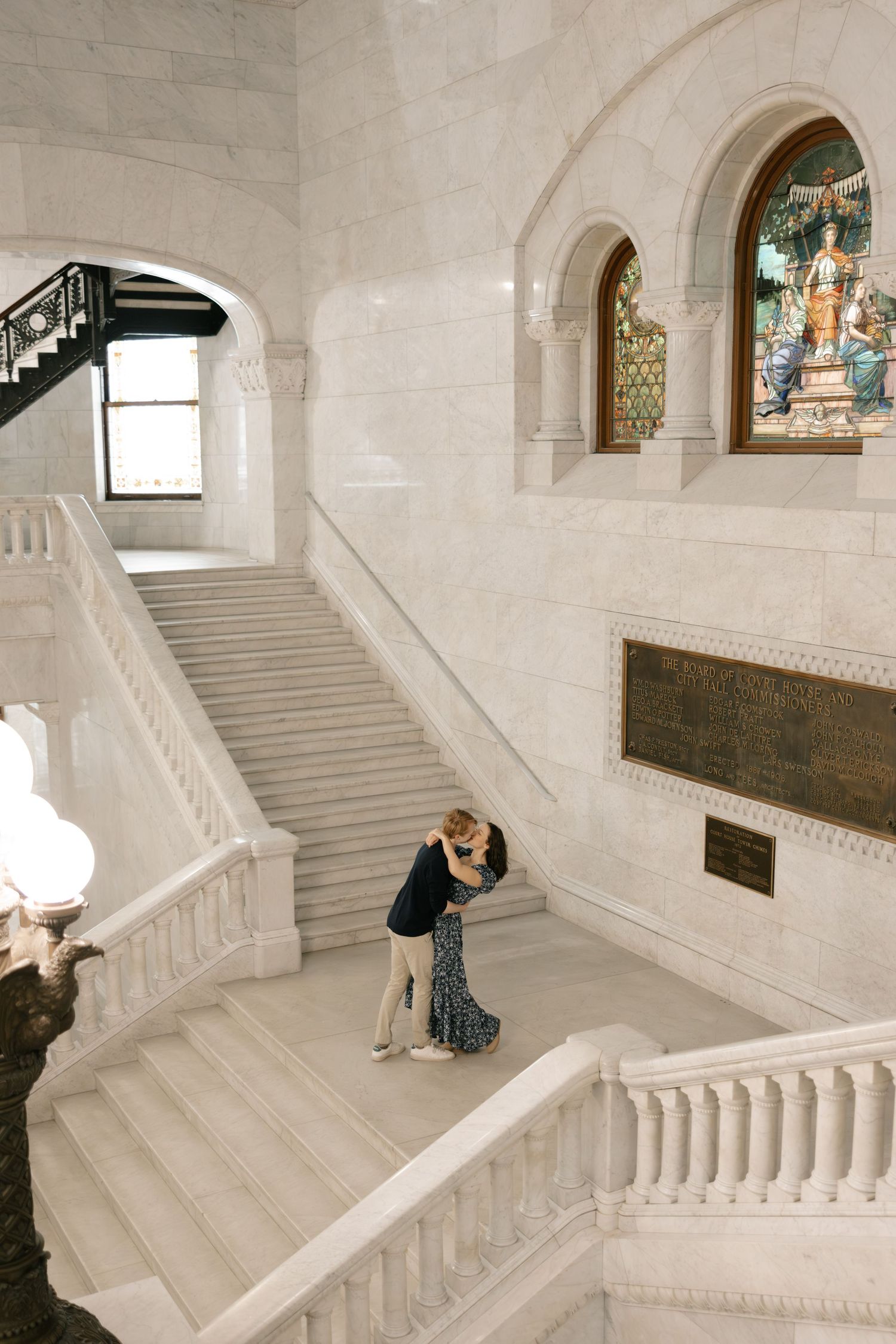 A series of four photos showing a grand white marble staircase in an ornate building with arched windows and architectural details.