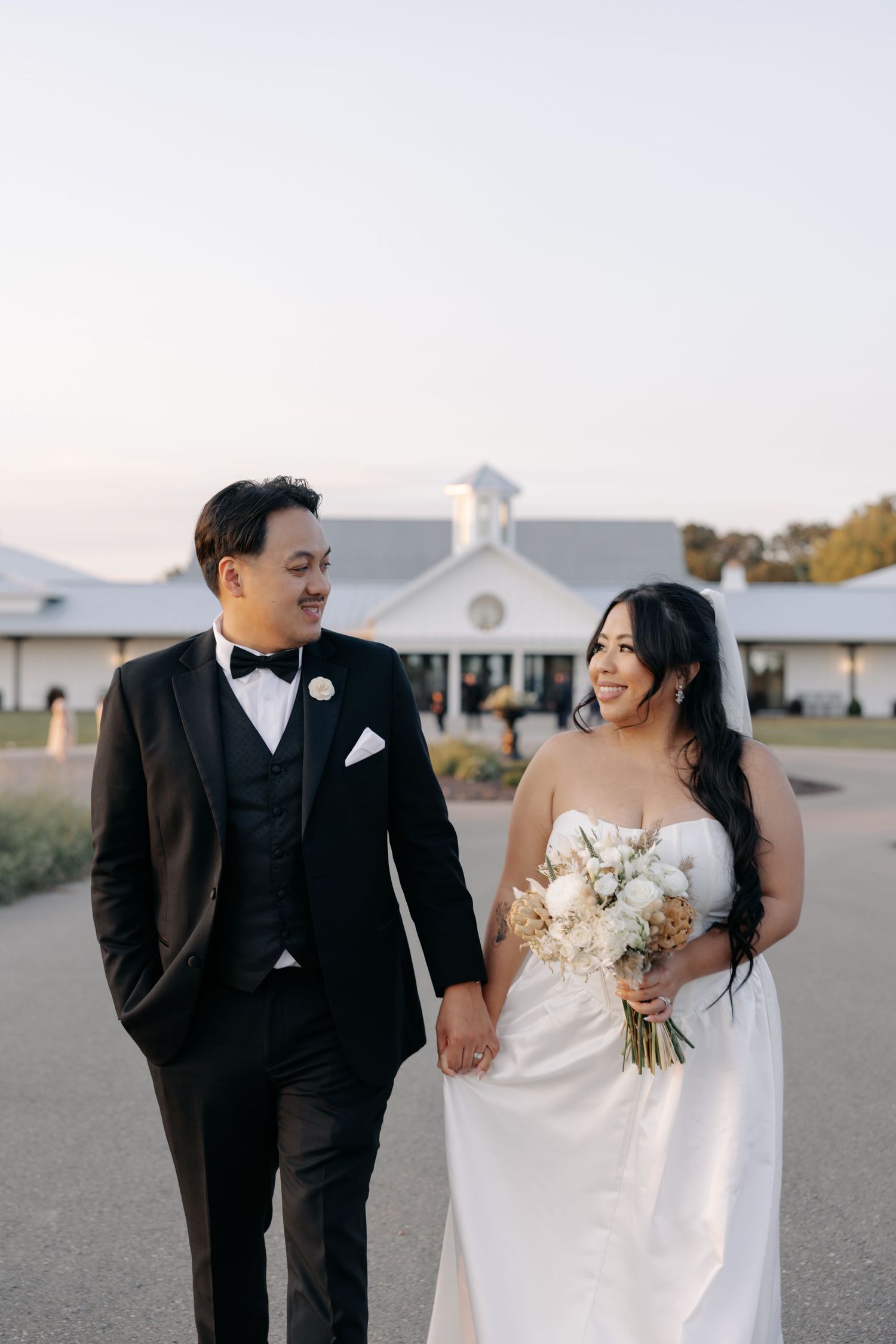 A couple shares joyful moments together during their wedding photoshoot on an outdoor road.