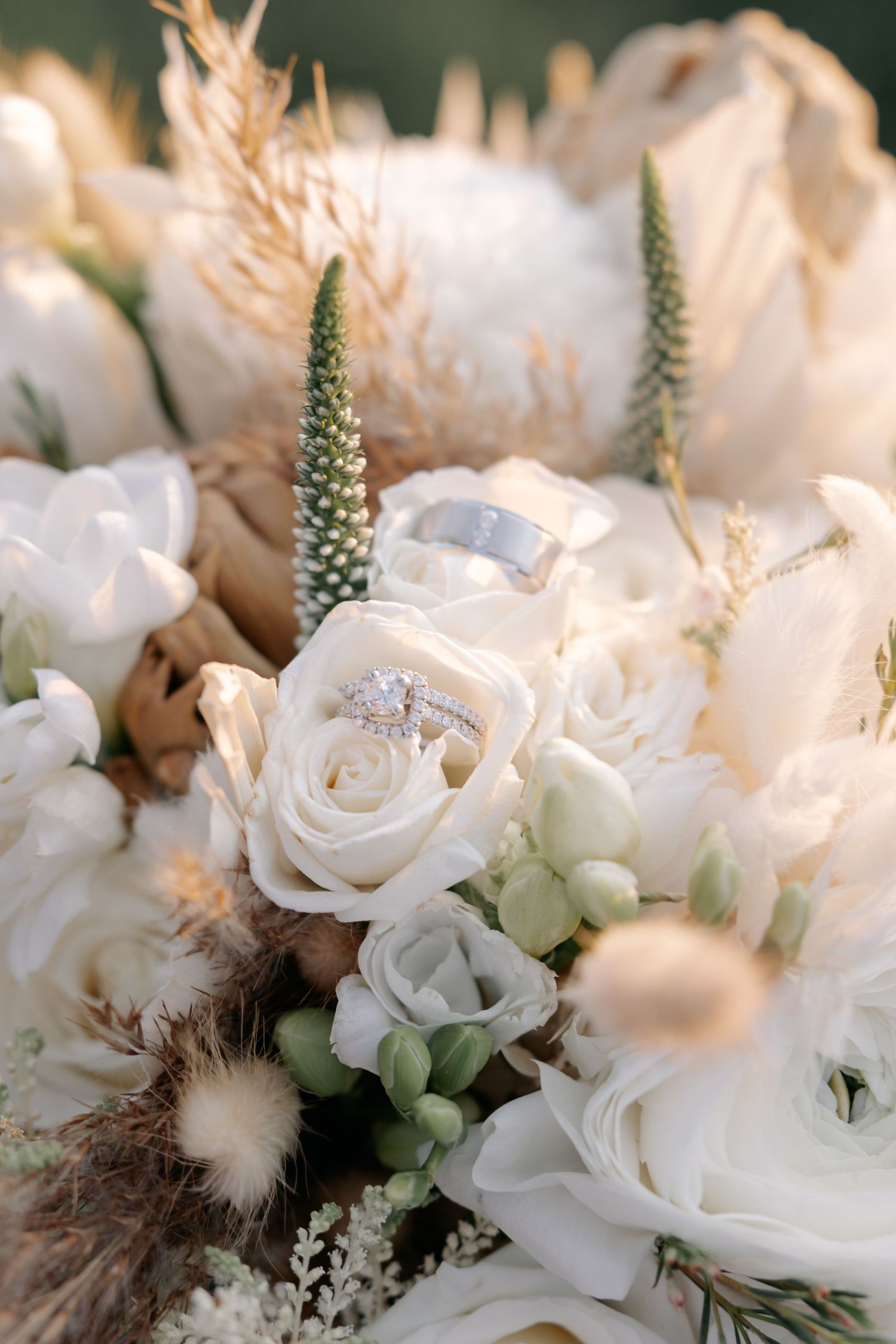 Close-up of elegant white roses and delicate floral arrangements with soft textural elements and greenery in natural light.